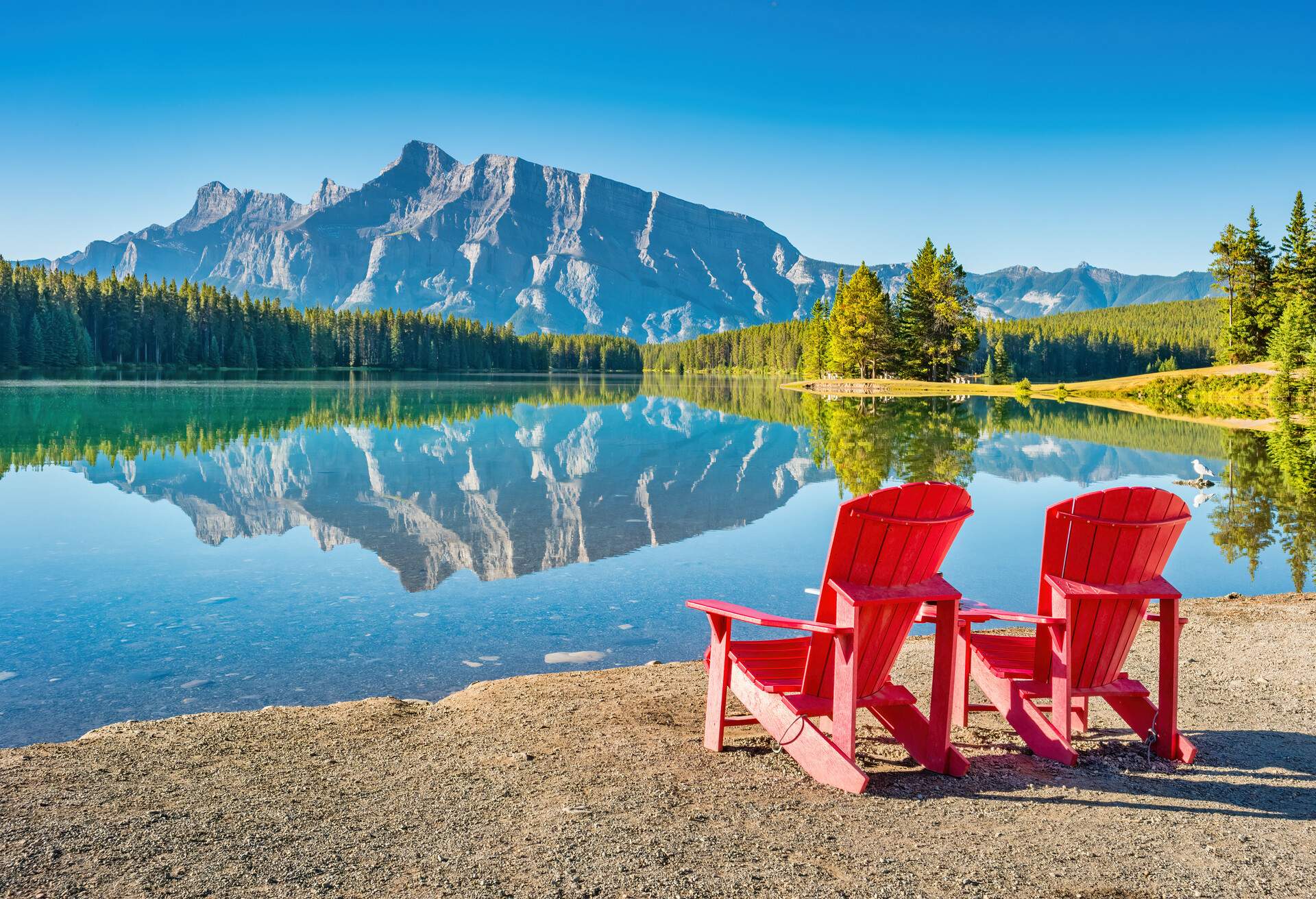 Tranquil landscape with Mt Rundle reflecting in Two Jack Lake, Banff National Park, Alberta Canada on a sunny morning.