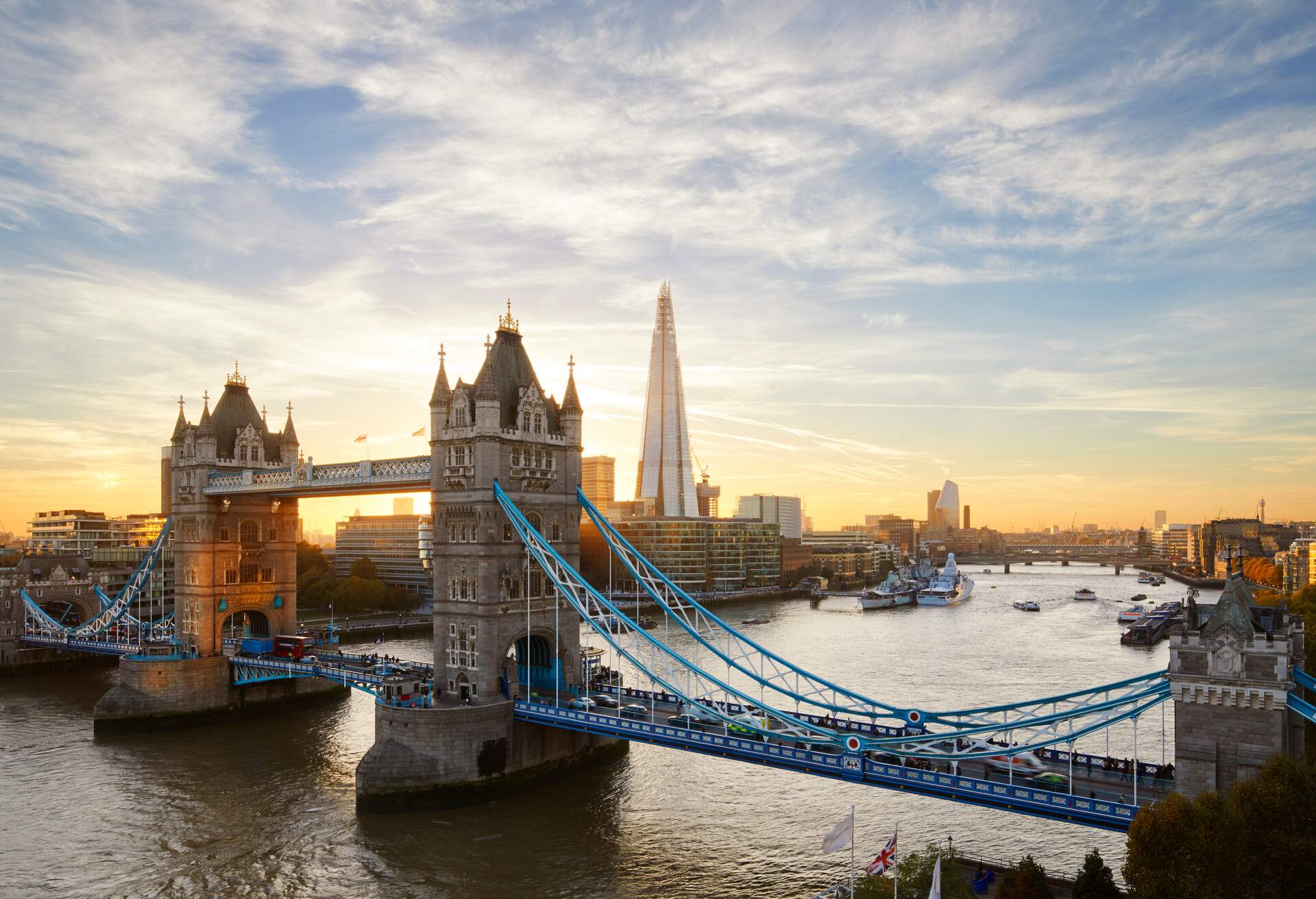 Vehicles passing through the Tower Bridge with The Shard in the background.