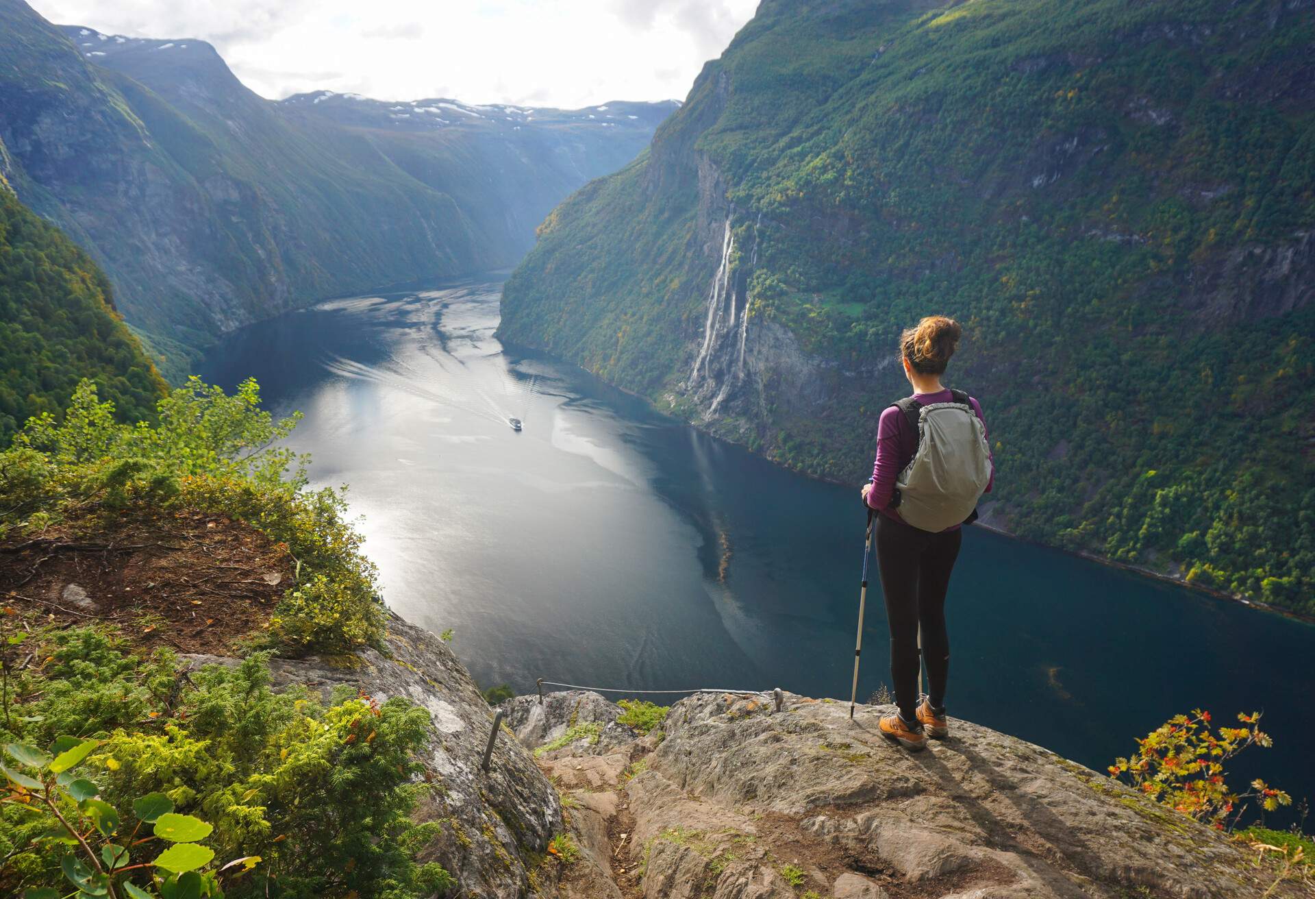 Female hiker admiring 7 sisters waterfall in Norway, Geiranger Fjord
