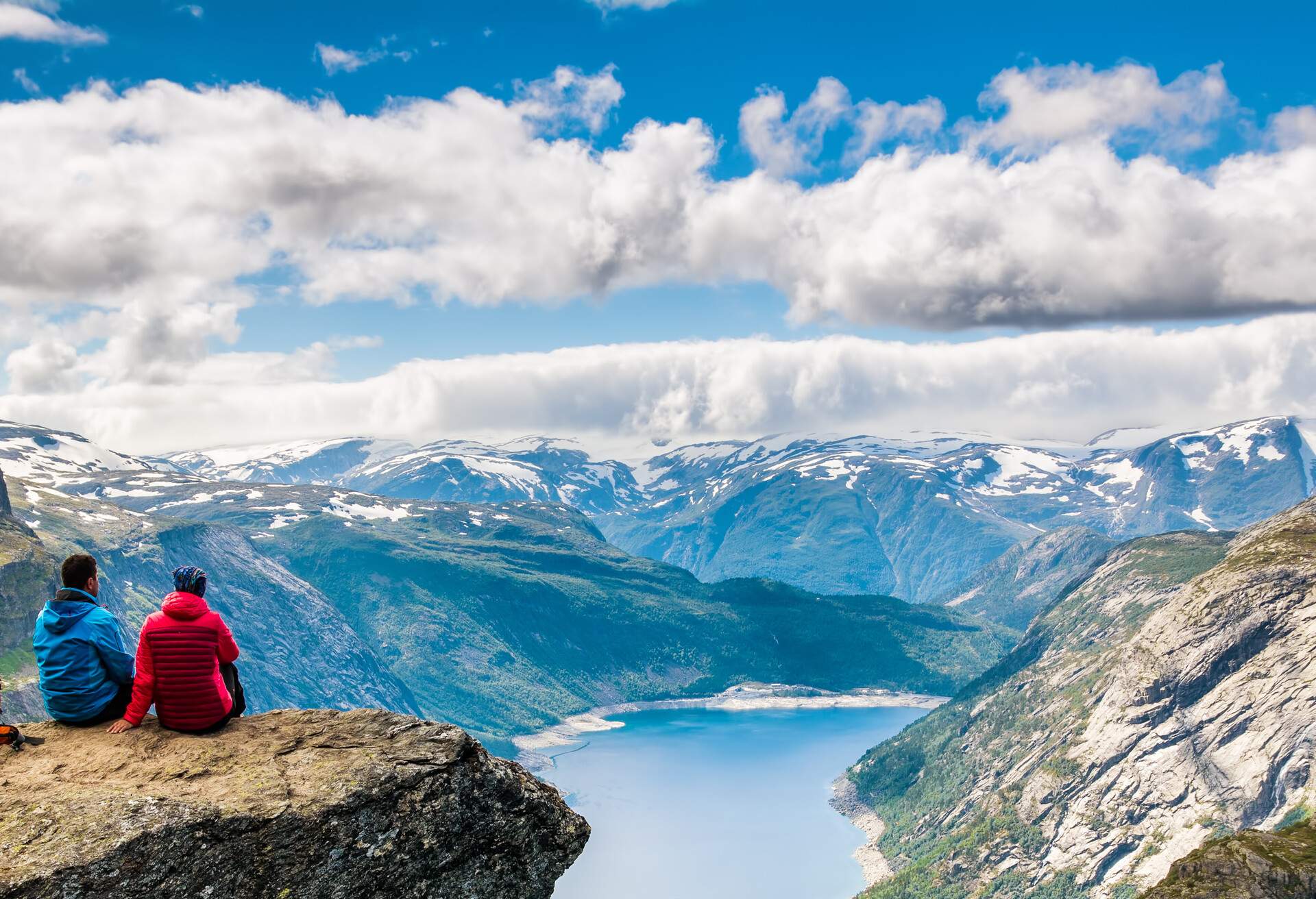 Couple sitting against amazing nature view on the way to Trolltunga. Scandinavian Mountains, Norway, Stavanger.