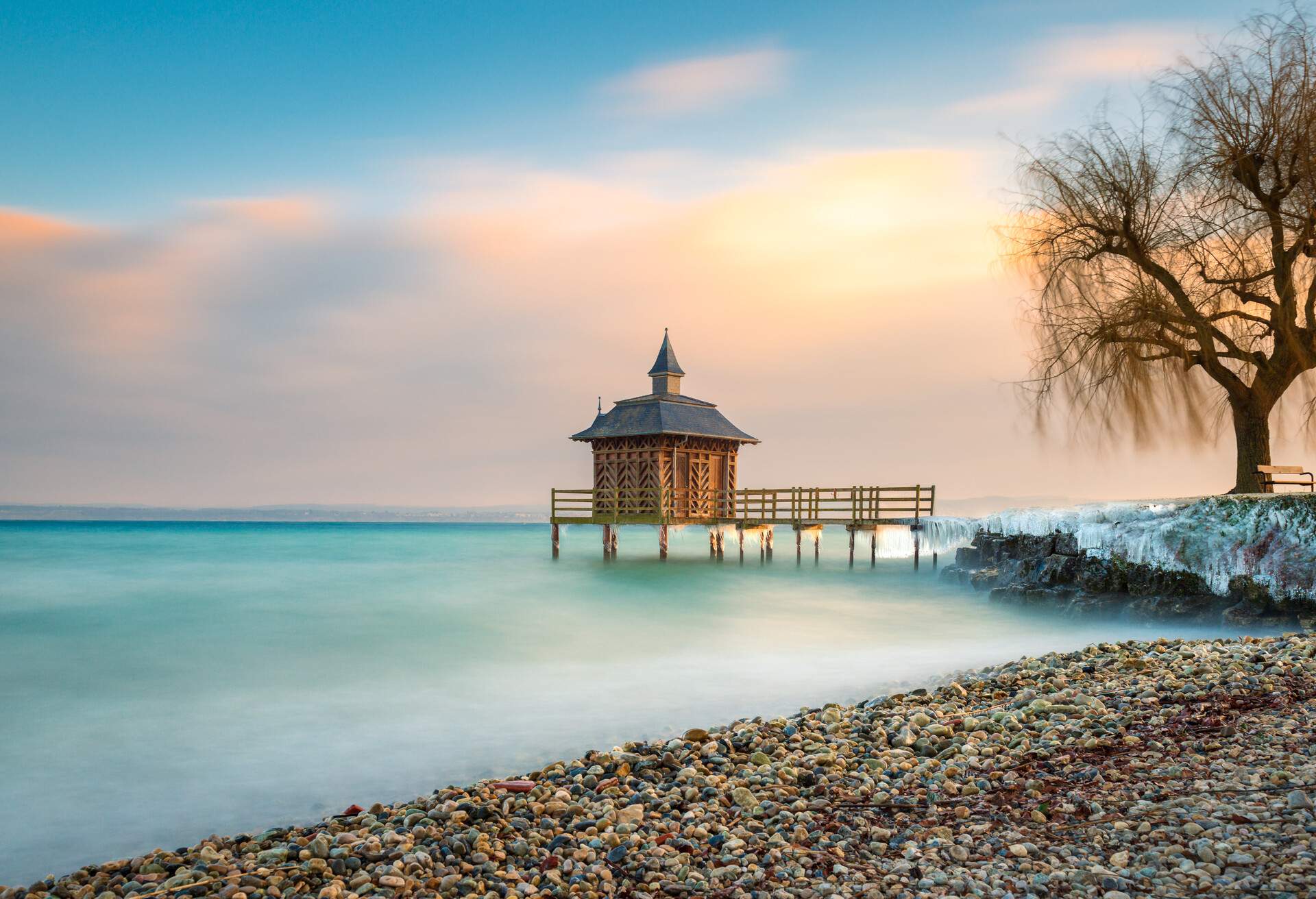 frozen water and icicle on the shore of the lake and on the pavilion jetty through the breaking waves. near Gorgier and the city of Neuchatel, canton Neuchatel, Switzerland