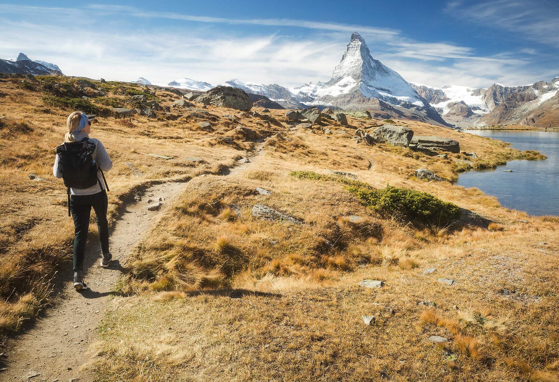 A female hiker explores a lake under the Matterhorn in Zermatt, Switzerland.