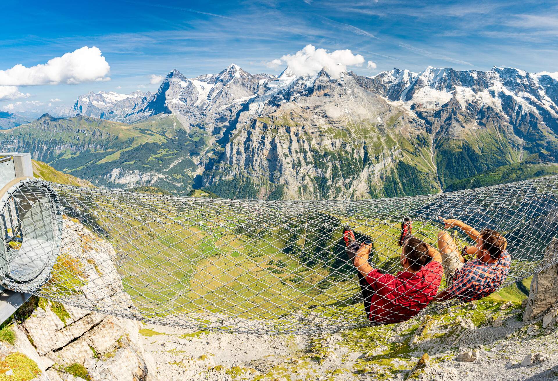 Two hikers inside a metal grated tunnel along the scenic Thrill Walk pathway, Murren Birg, Jungfrau, Bern canton, Switzerland