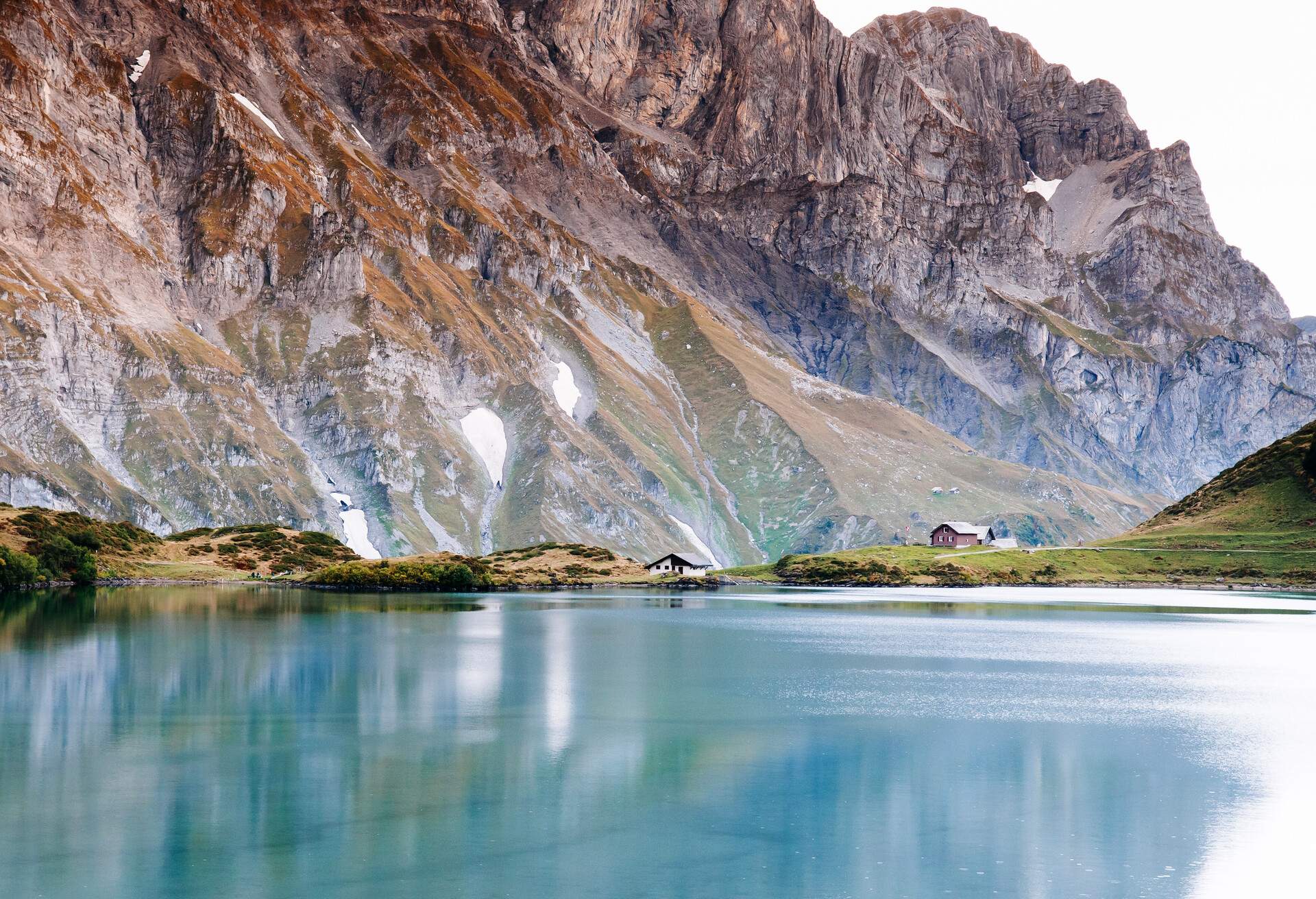 Rural landscape scenery with small cottage on Trubsee lake  shore, Swiss alps Mount Graustock peak on background, foot of mount Titlis in Engelberg