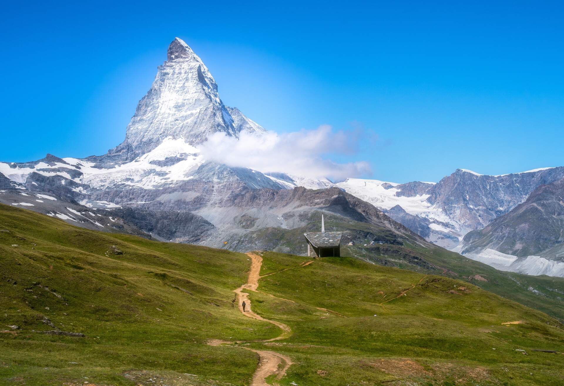 Alone traveler walking through the way head to the Matterhorn in the sunny day