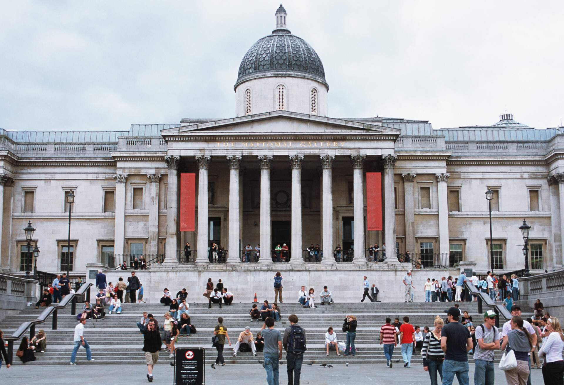 National Gallery is a neoclassical museum that features a crowded front staircase, a pillared porch, and dome roof.