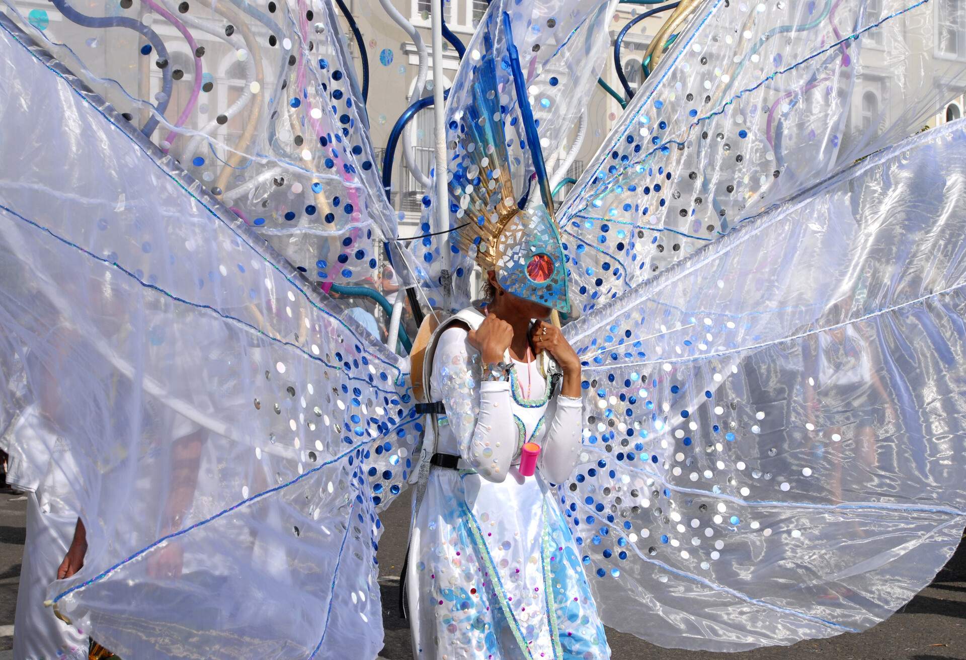 A woman dressed in a fancy blue and white costume decorated with reflective sequins.