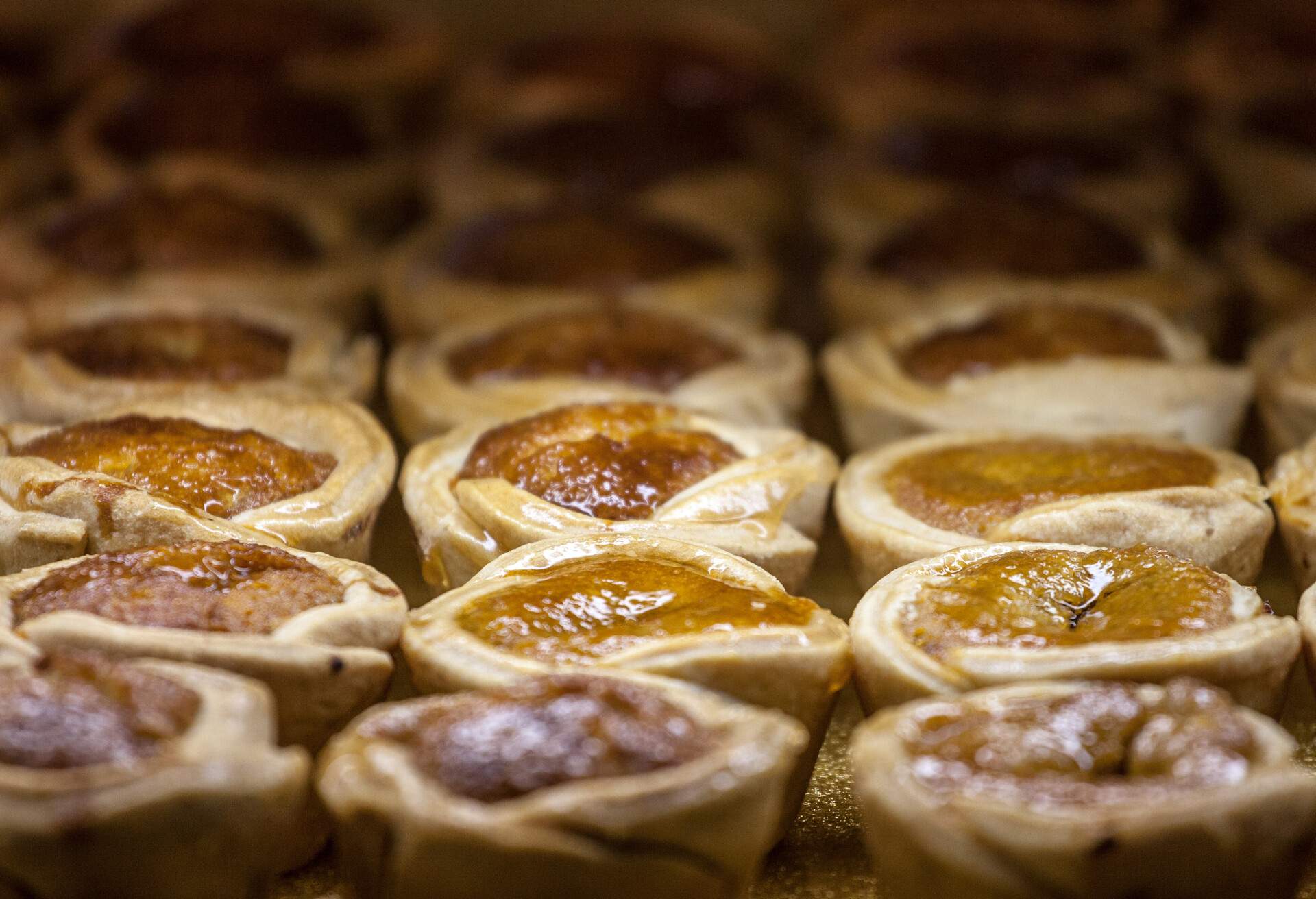 Picture of rows of butter tarts for sale on a market of Toronto, Canada. A butter tart is a type of small pastry tart highly regarded in Canadian cuisine and considered one of Canada iconic treats.