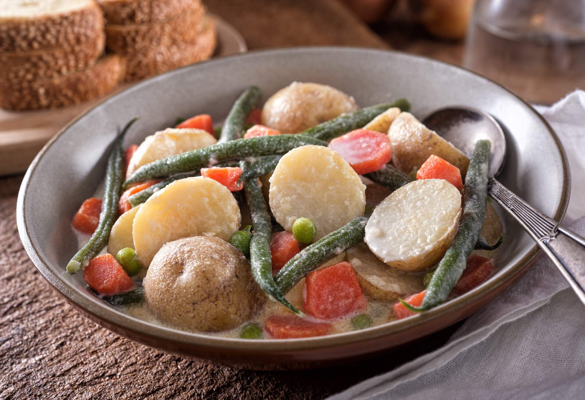 A delicious homemade Nova Scotia hodge podge vegetable stew with garden fresh potato, green beans, carrots and peas with cream.