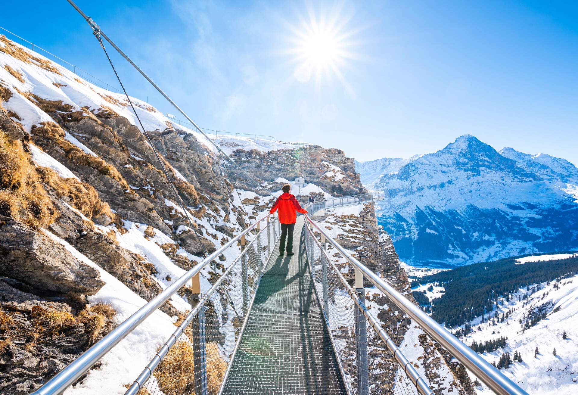 One person walking on a thrilling metal walkway clinging to the cliffside in Grindelwald, Berner Oberland, Switzerland