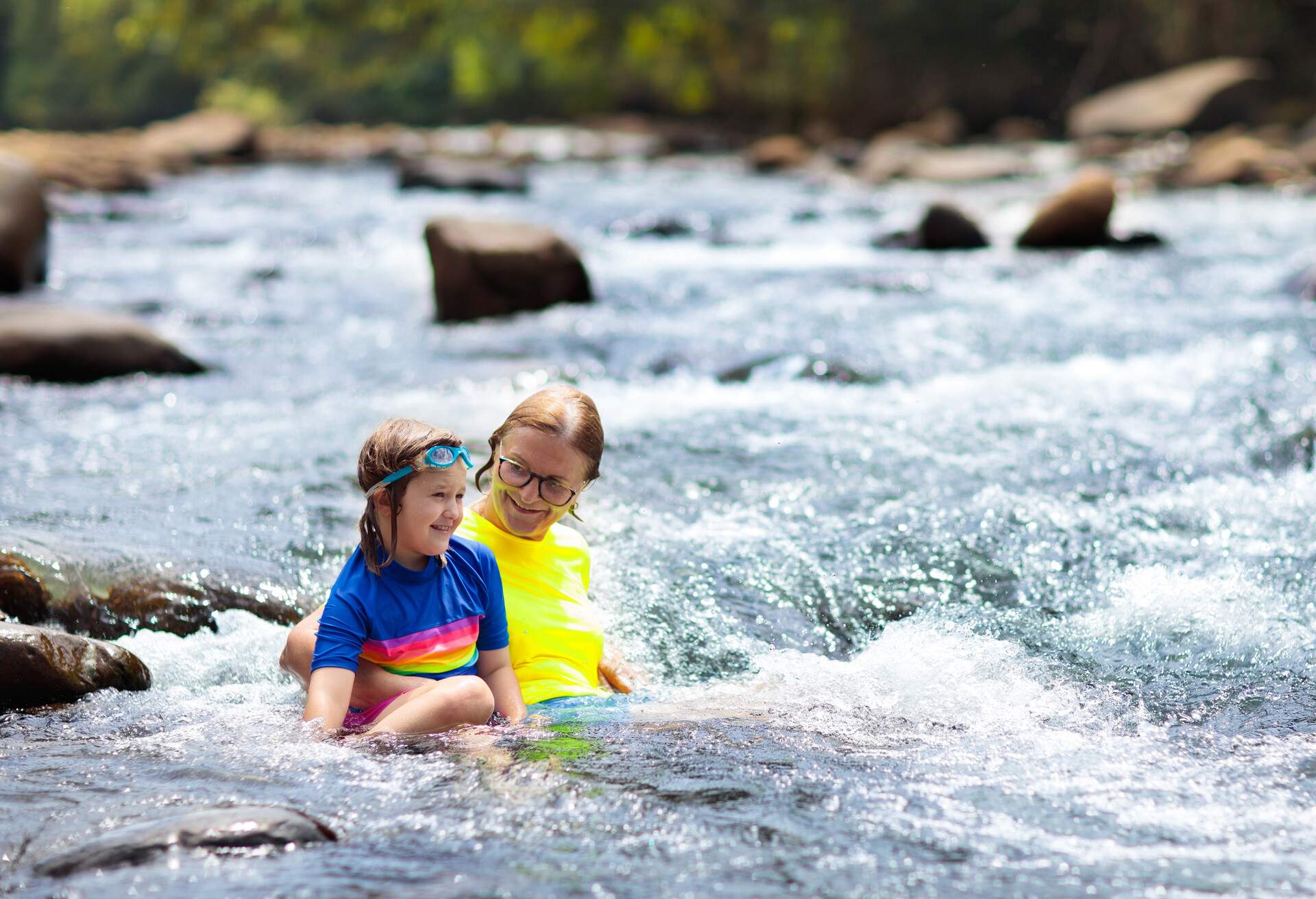 family travel austria - grandmother and child swimming in waterfall