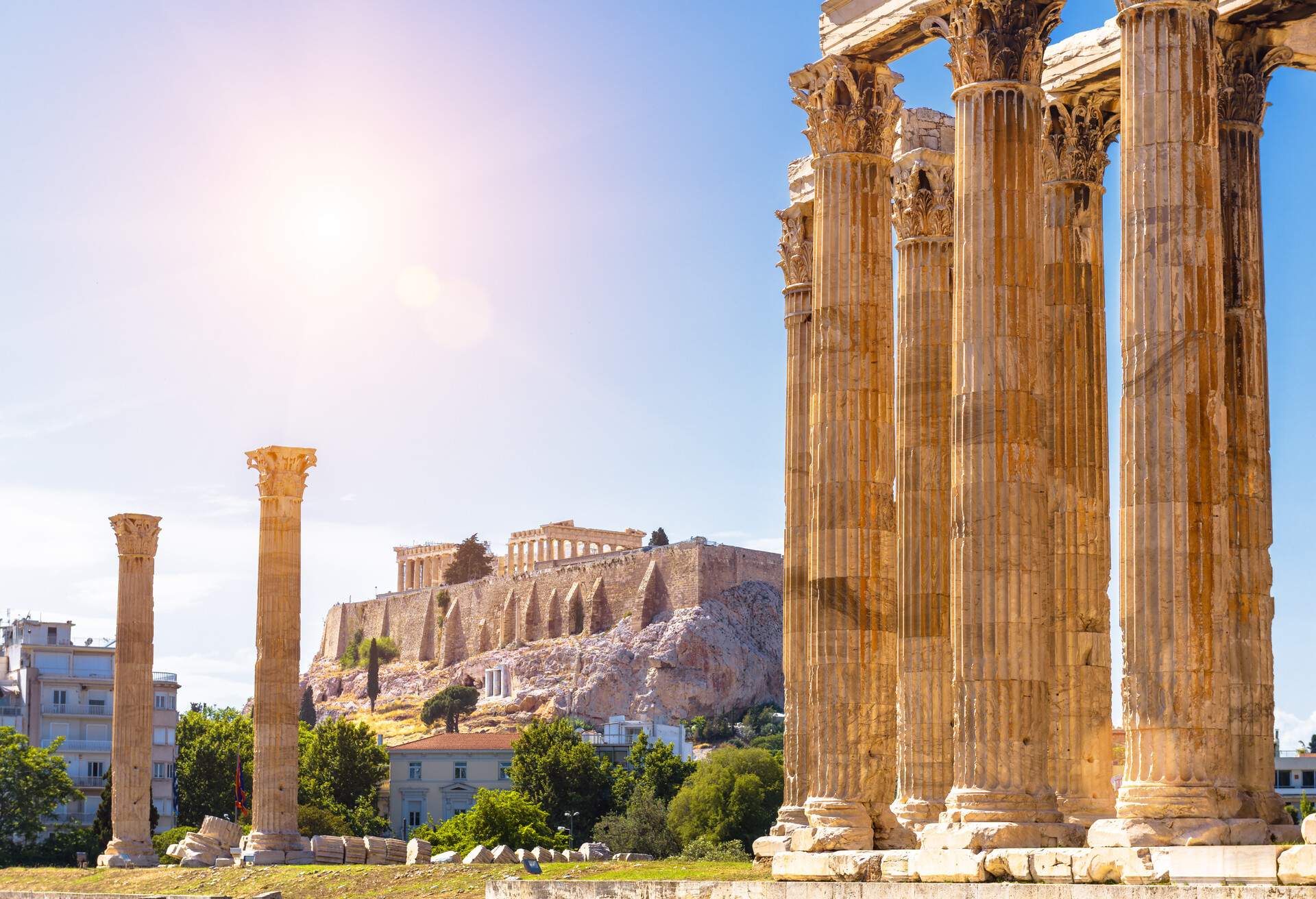 Zeus temple overlooking Acropolis, Athens, Greece. These are famous landmarks of Athens. Sunny view of Ancient Greek ruins, great columns of classical building in Athens city center. Travel concept.