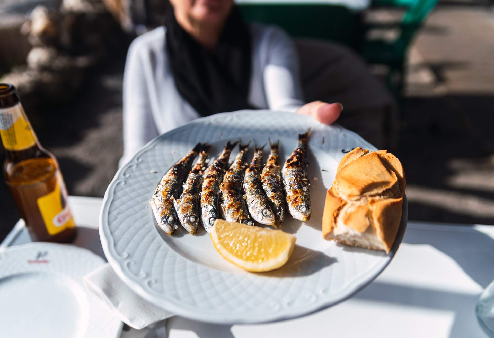 SPAIN_MALAGA_WOMAN_HOLDING_PLATE_FRESHLY_COOCKED_GRILLED_SARDINES