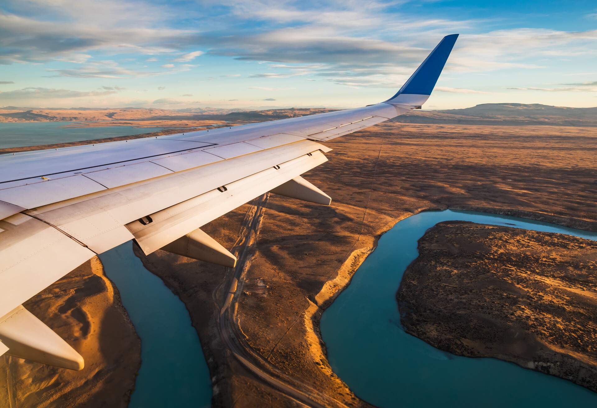 VIEW FROM AIRPLANE WITH PLANE WING AND CANYON LANDSCAPE