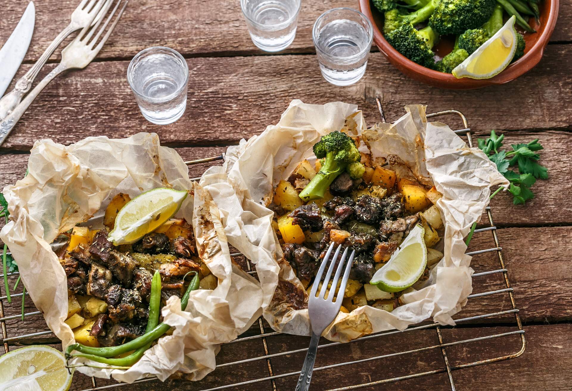 Traditional Greek kleftiko, an oven-baked lamb stew with potato, olive oil, onion, carrot, garlic and herbs, served with lemon and ouzo