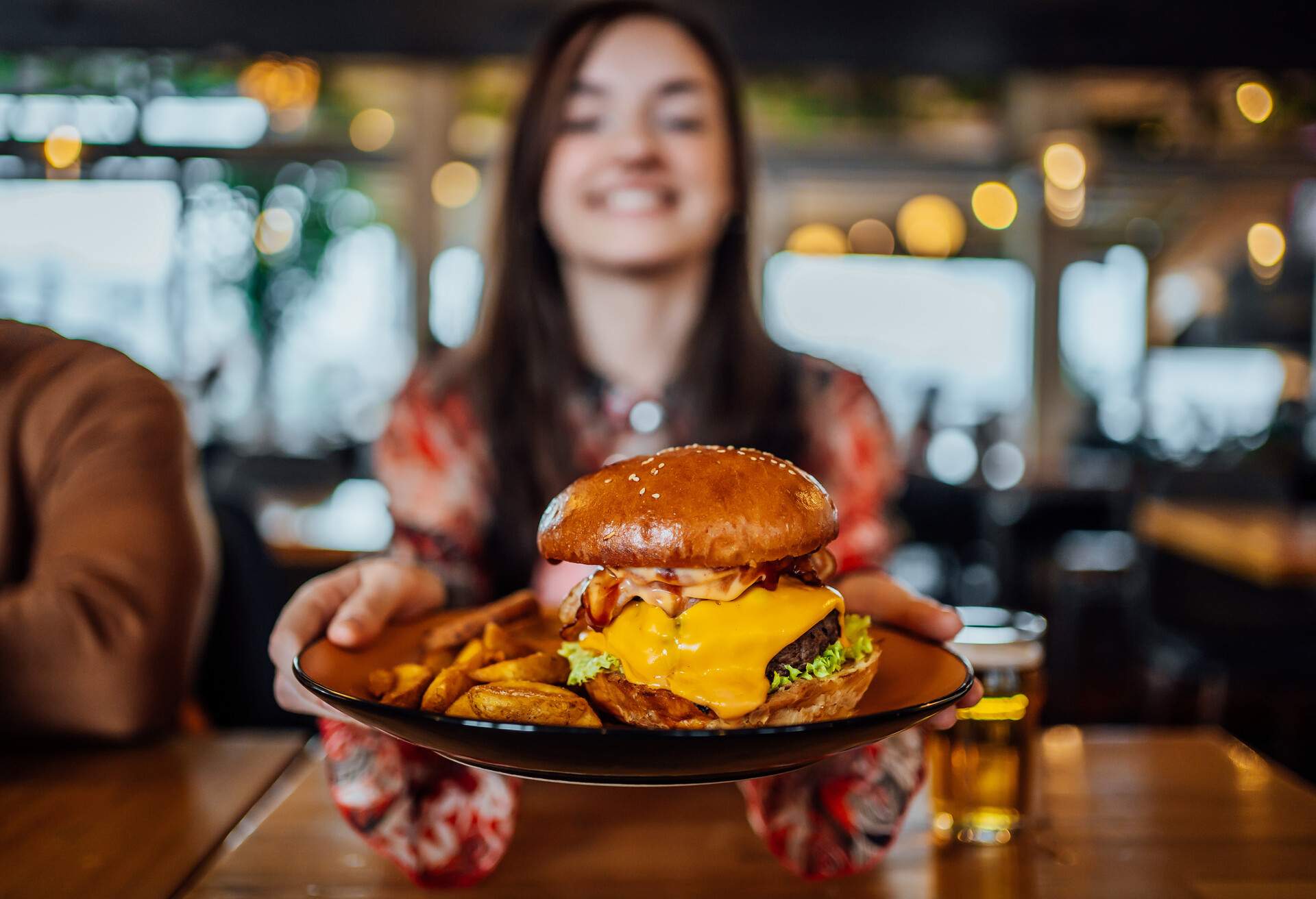 FOOD_RESTAURANT_WOMAN_HOLDING_PLATE_WITH_BURGER