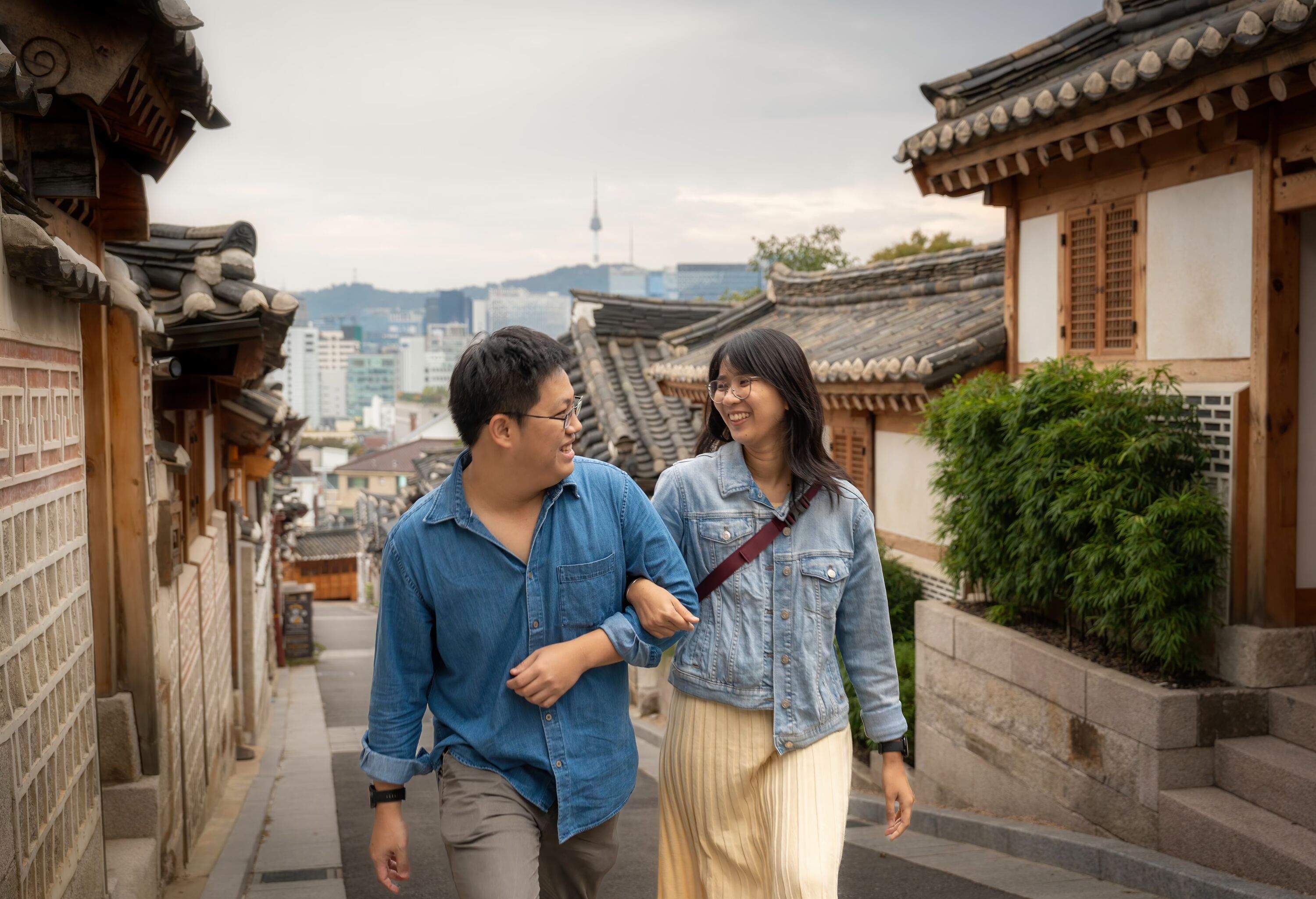 Couple walking through Bukchon Hanok village holding hands and walking together in romantic scene Seoul. South korea