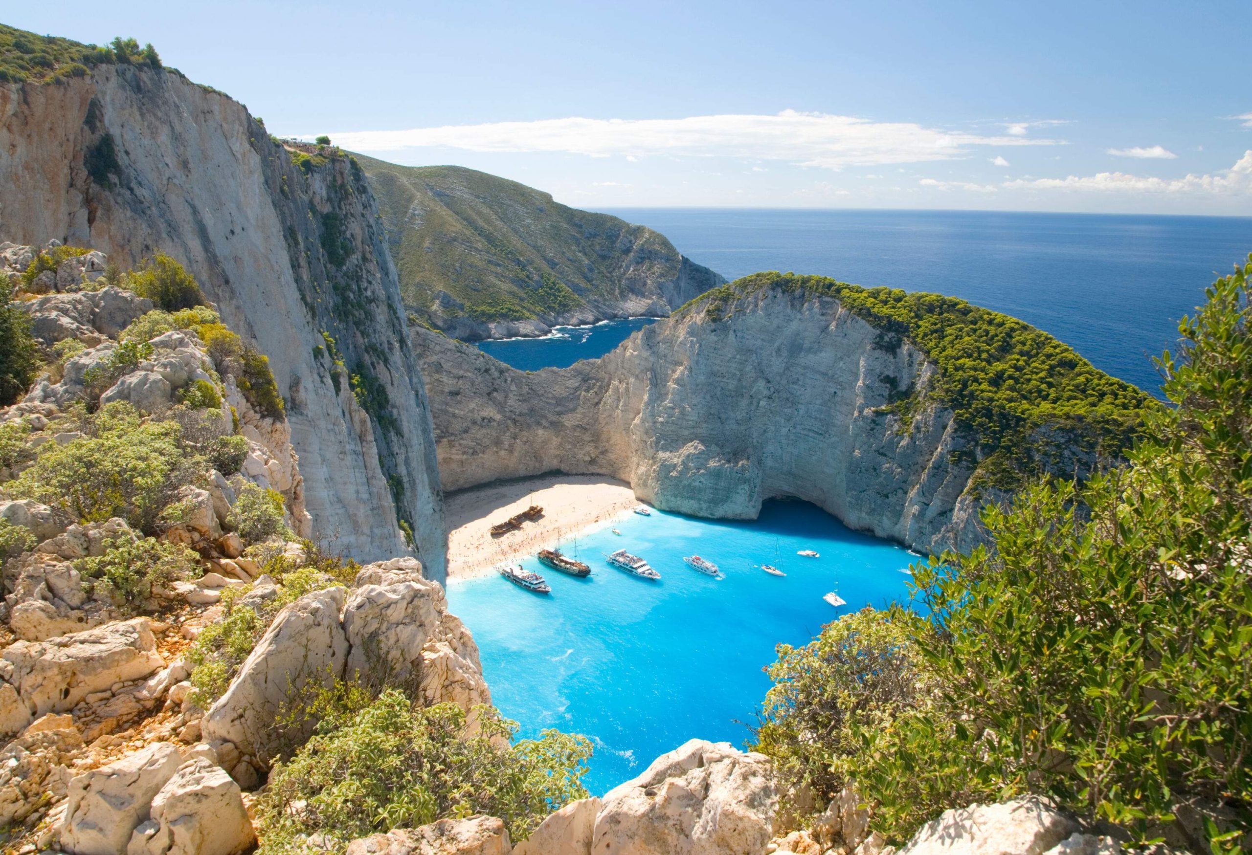 There were pleasure boats anchored off the beach, flanked by cliffs, with the turquoise ocean in the background.