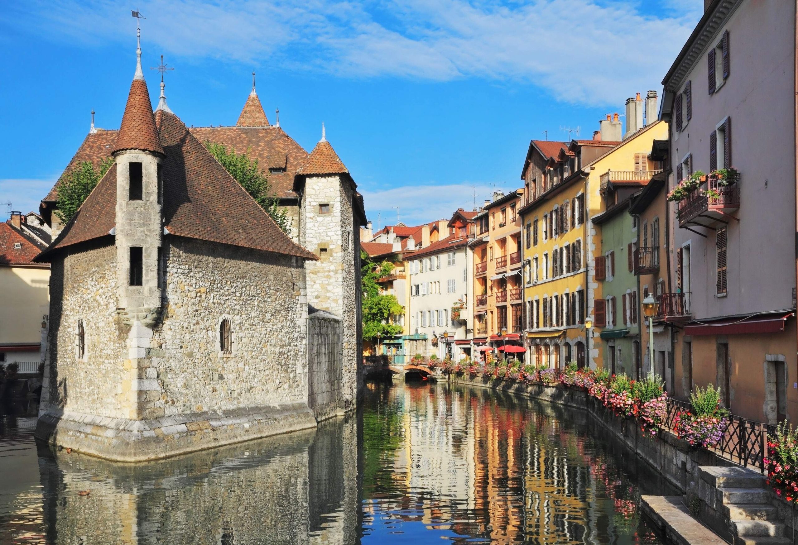 A river canal lined with adjacent buildings and stone houses with turrets.