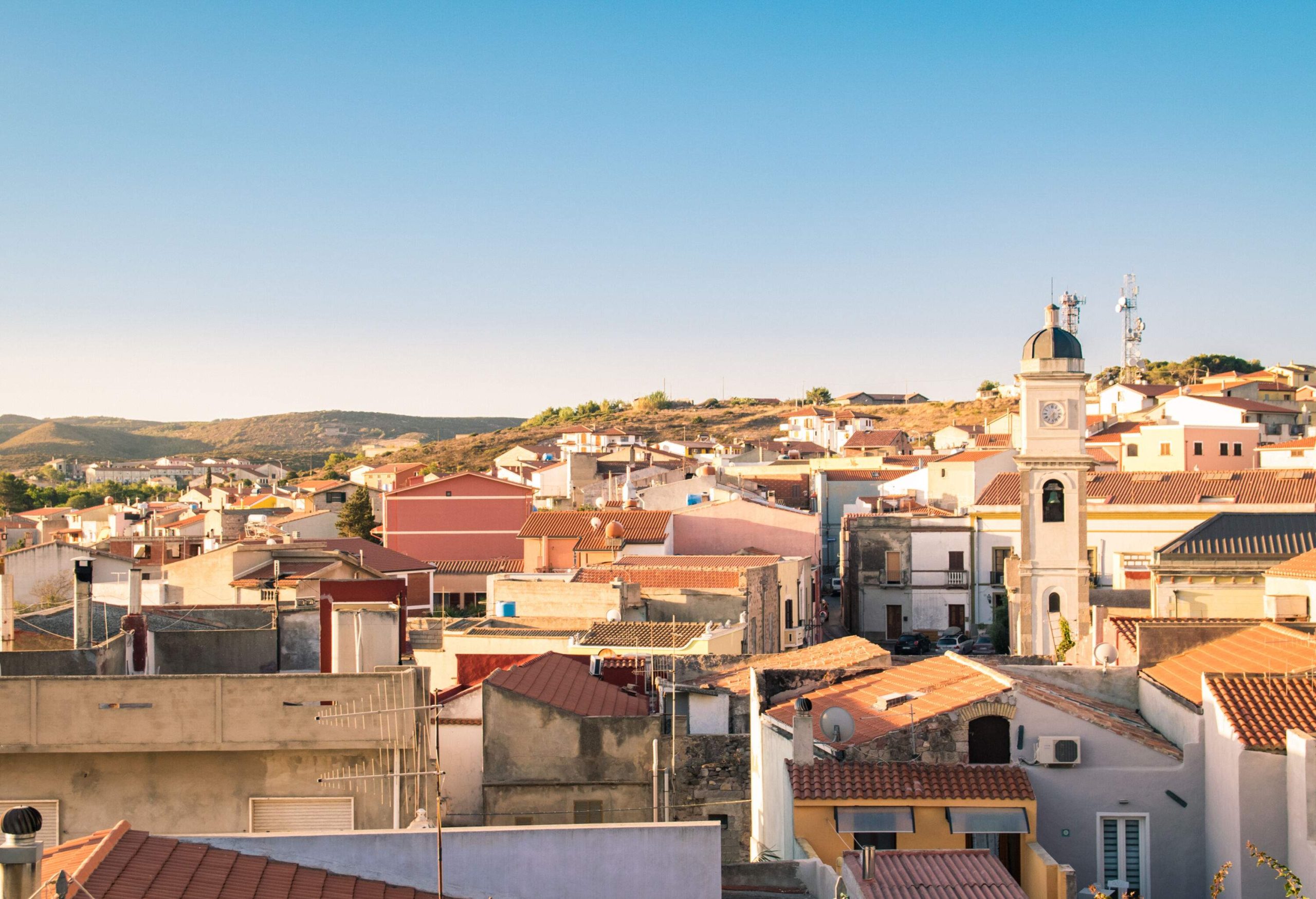 Skyline view of a town with classic brick-roofed houses against the clear blue sky.