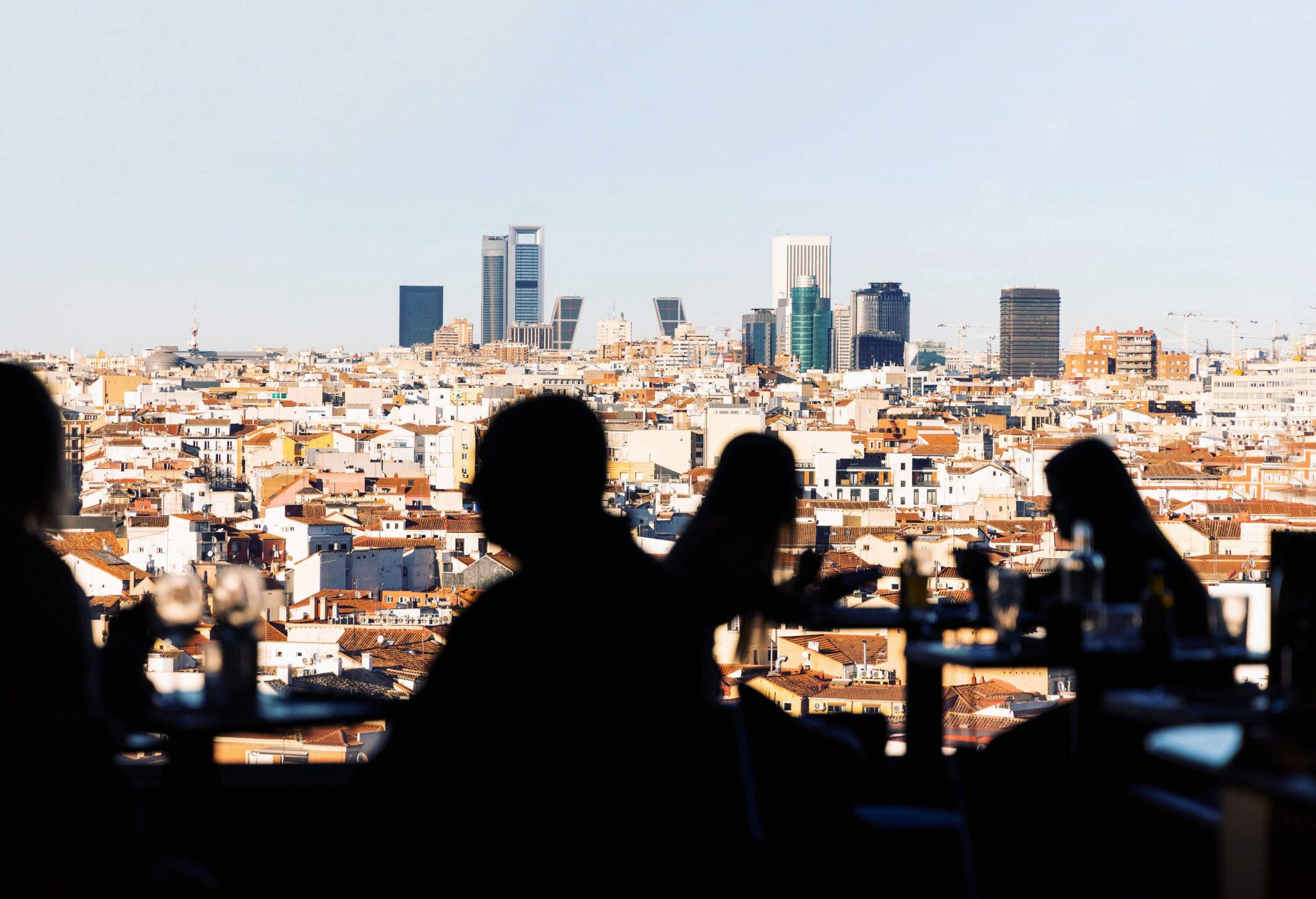 Silhouette of people against the urban cityscape with classic and modern buildings.