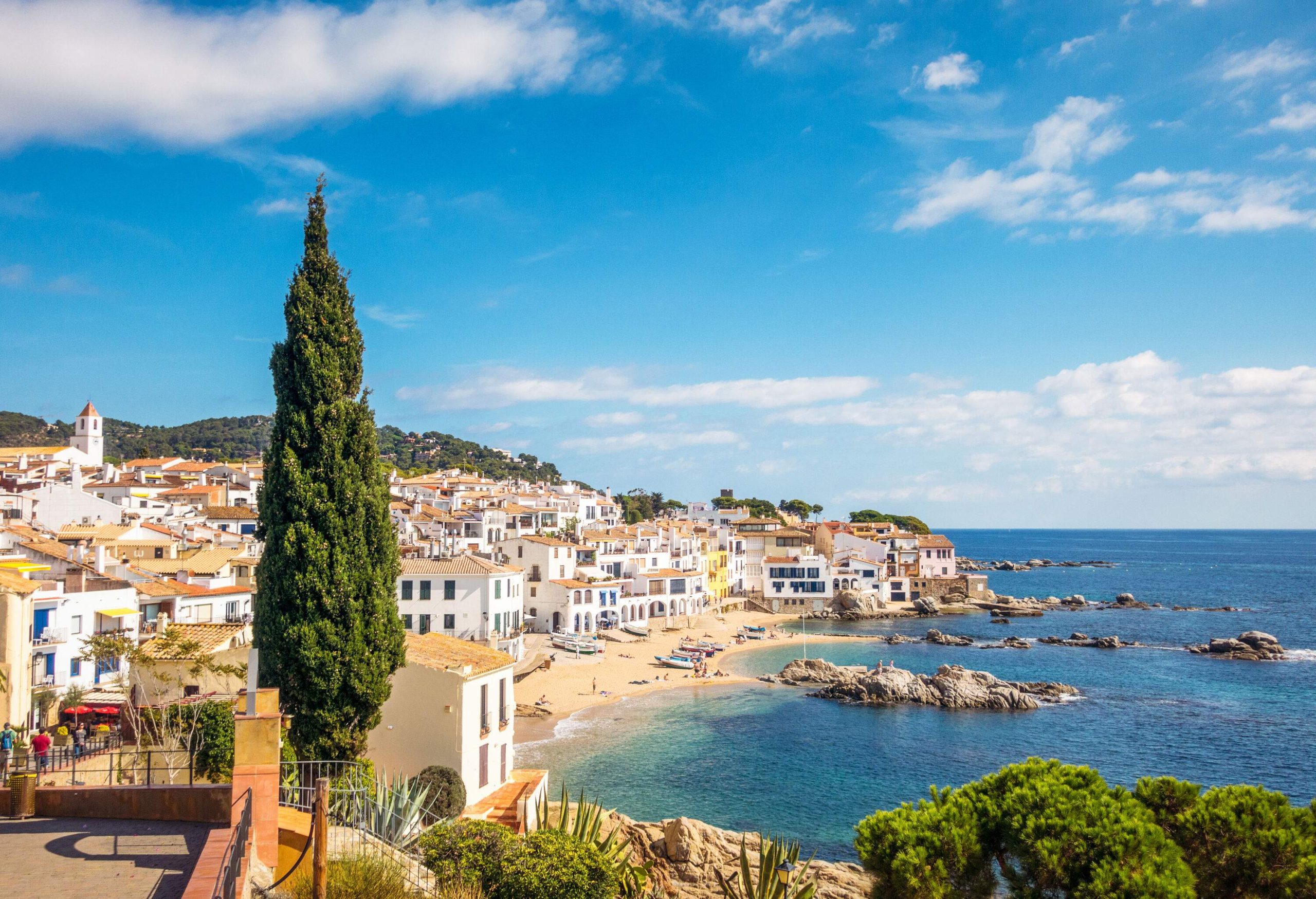 A rocky cove with a village of whitewashed buildings along the shore.