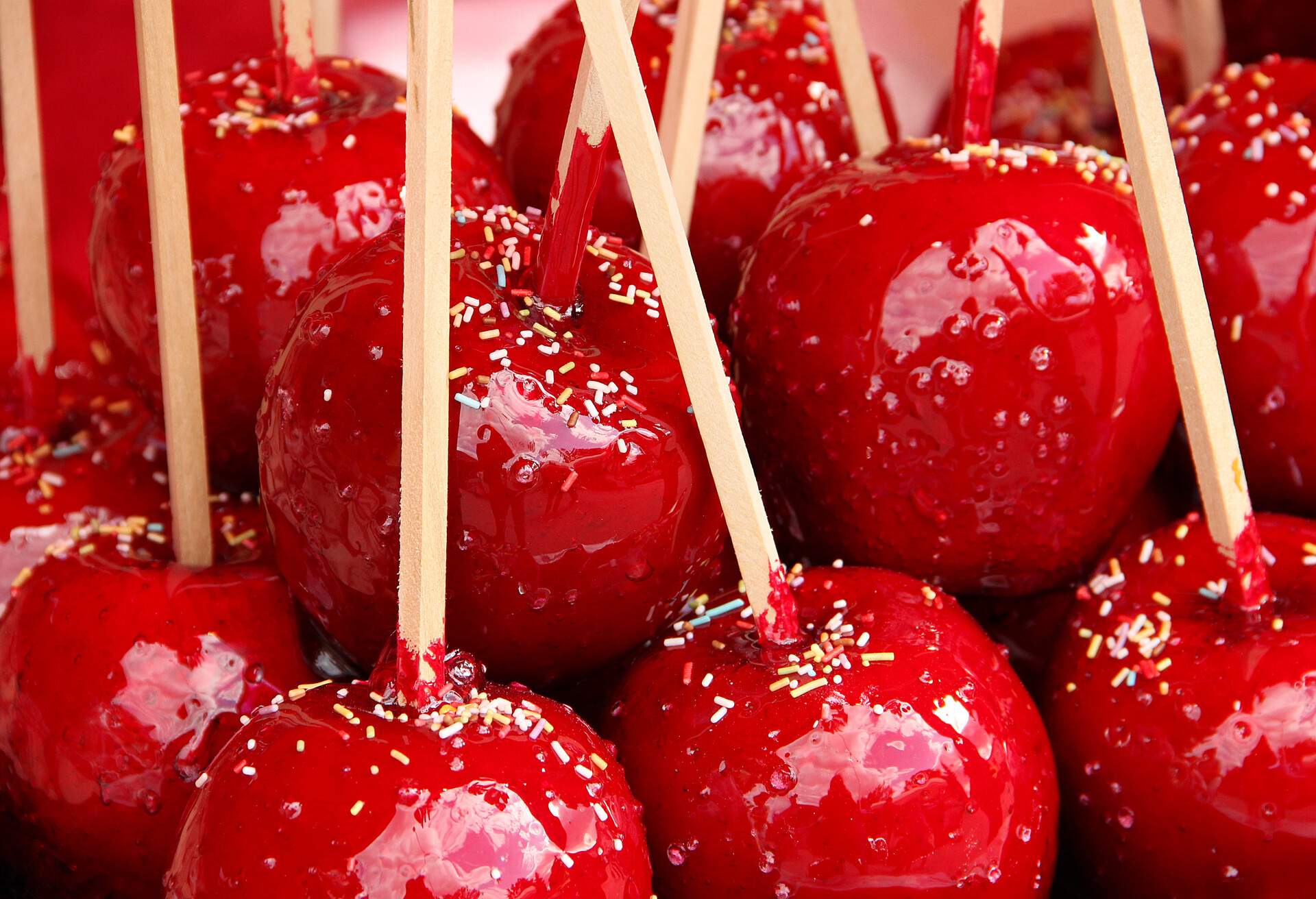 Sweet red candy apples covered with colorful sprinkles.