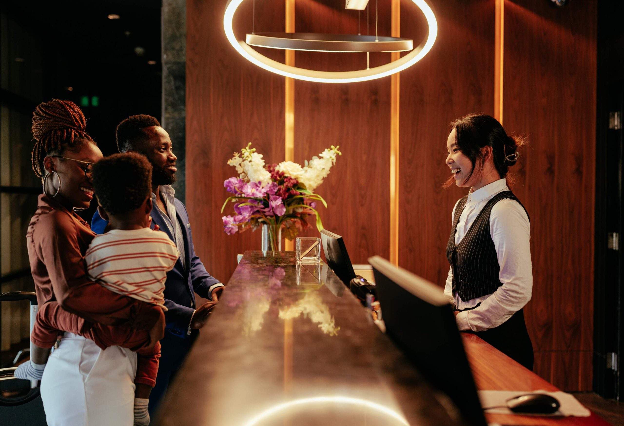 theme_people_family_hotel_couple_woman_desk_lobby_reception_gettyimages-1428674946-copy-scaled