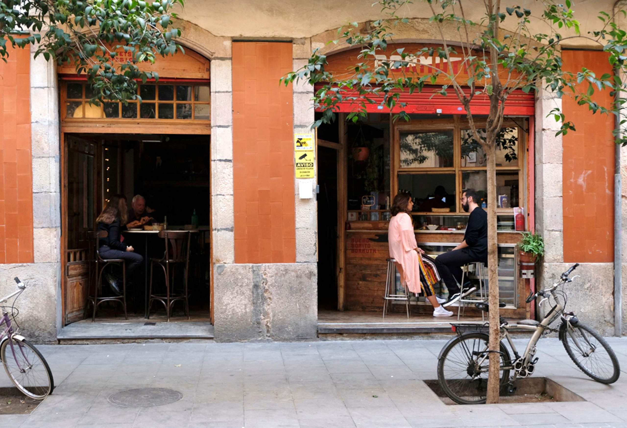 People are seated inside a rustic restaurant, seen from the outside.