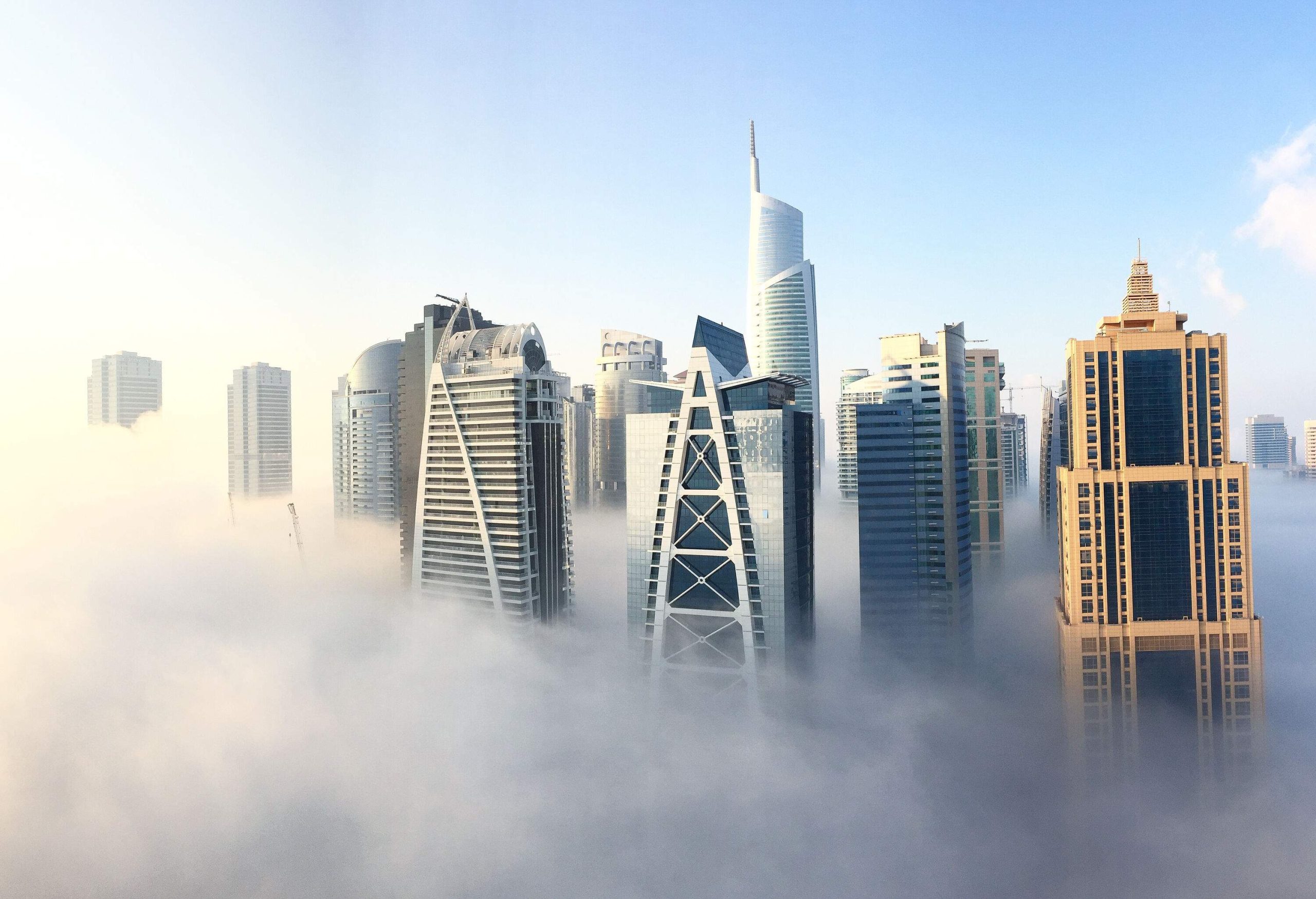 A compact cluster of tall buildings covered with fog.