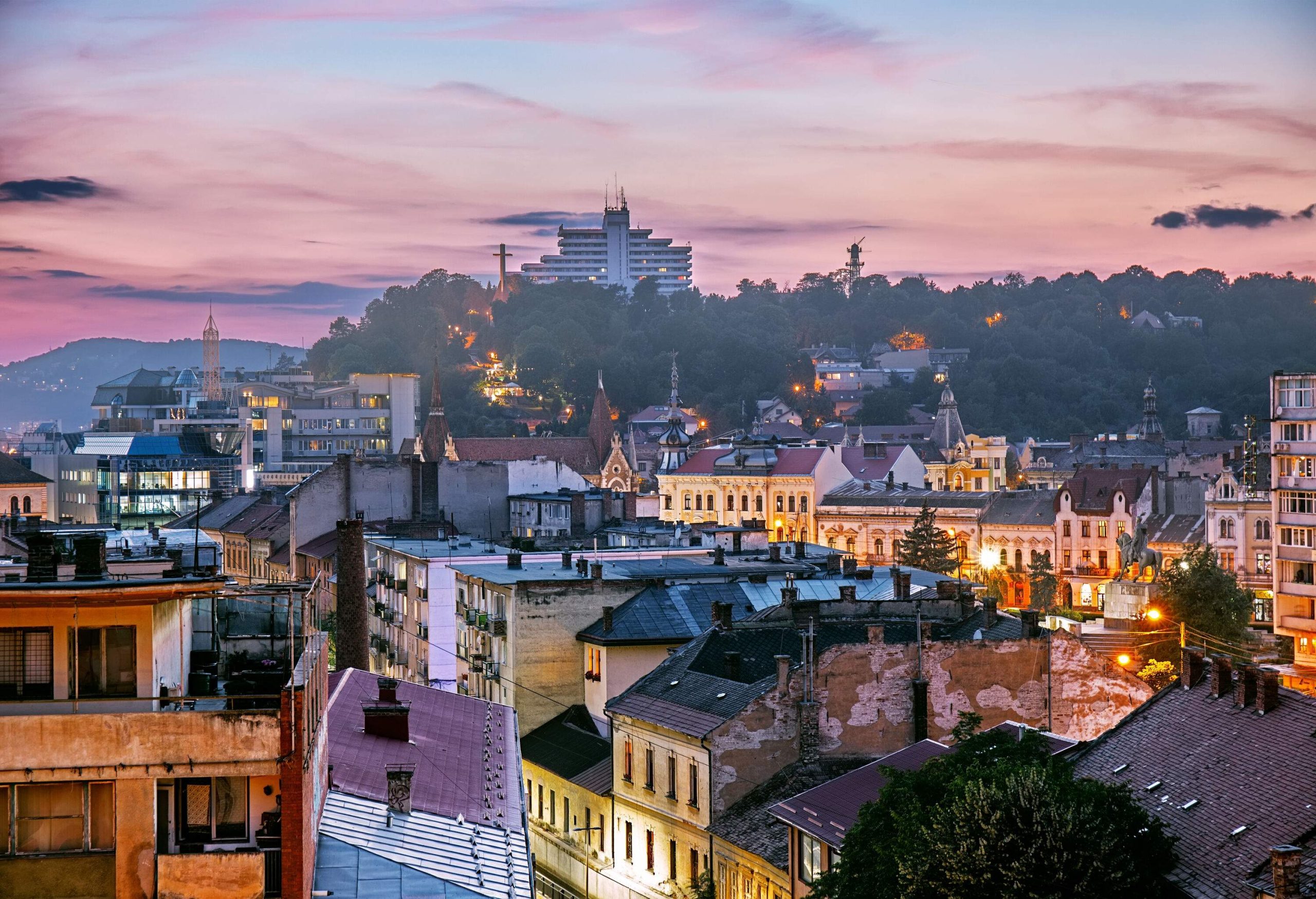 A charming townscape nestled amidst trees, with a building discreetly peeking from behind the lush foliage.