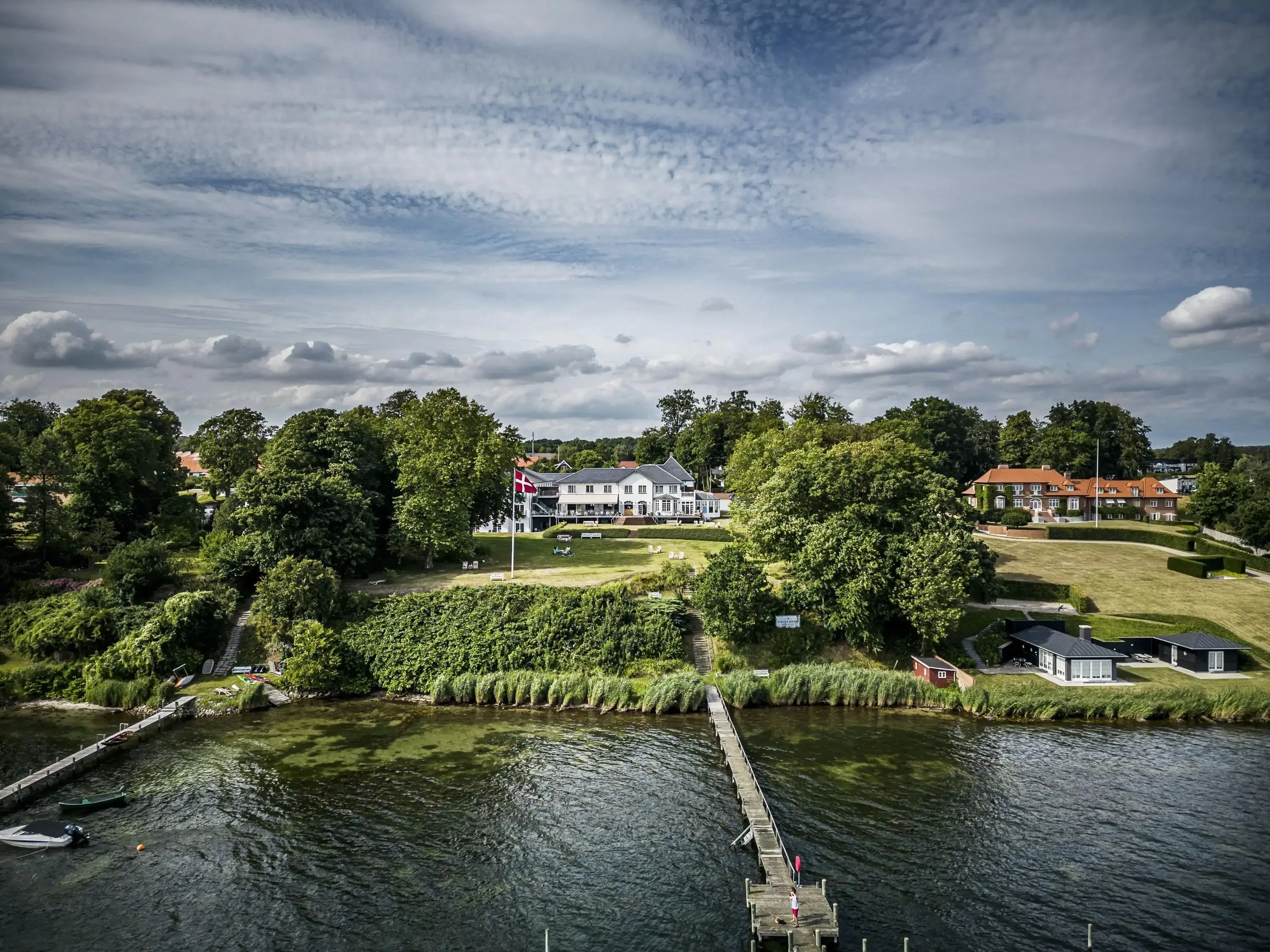 Aerial view of a manor by the sea with a jetty