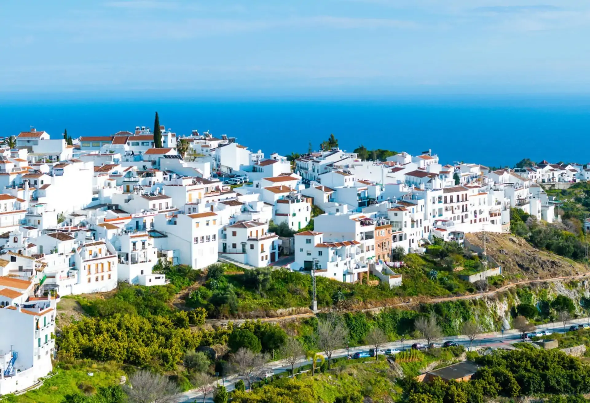 Whitewashed coastal village perched on a hillside overlooking the blue Mediterranean Sea.