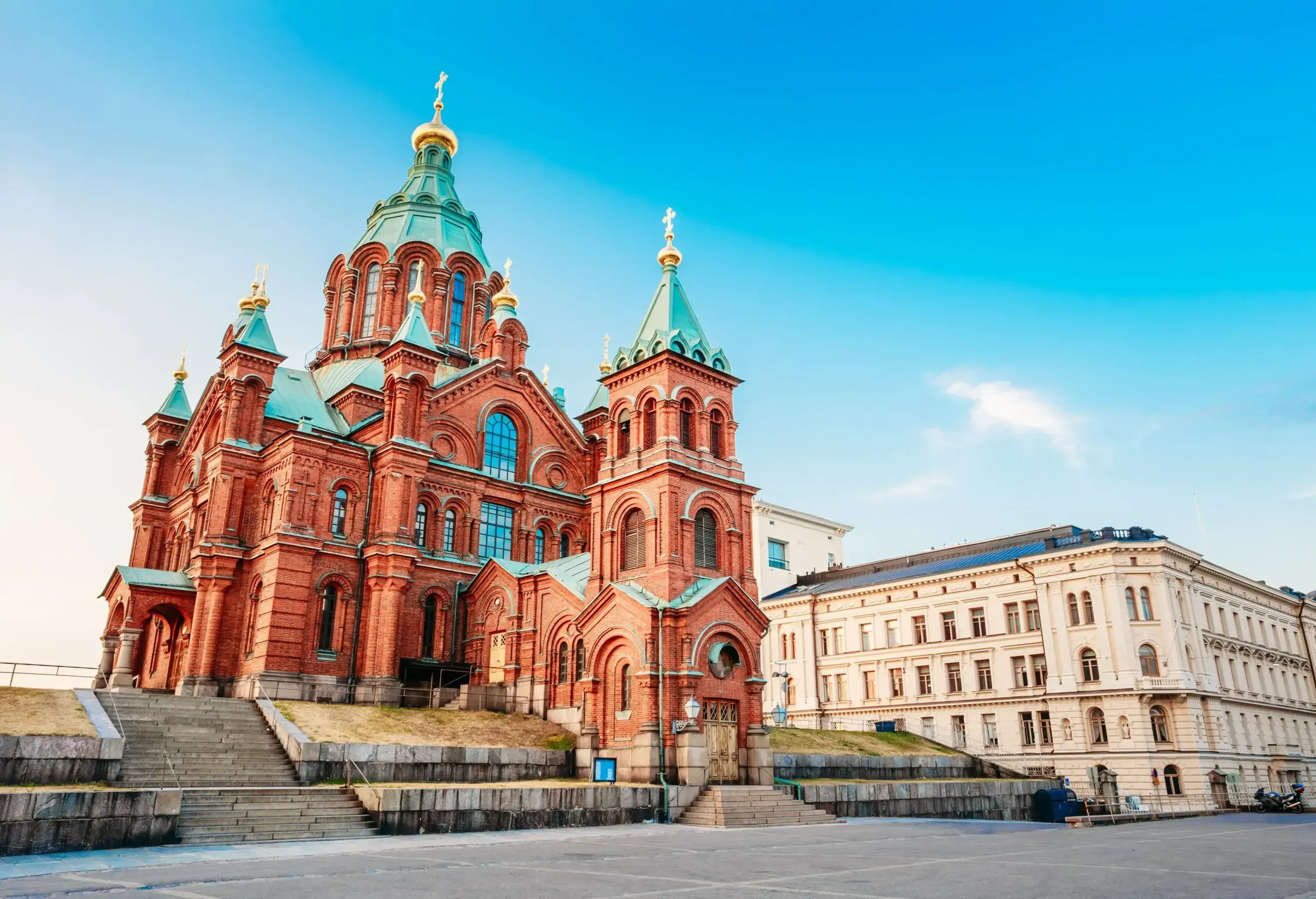 An enormous redbrick Greek Orthodox church with a bell tower and a dome crowned with a golden cupola.