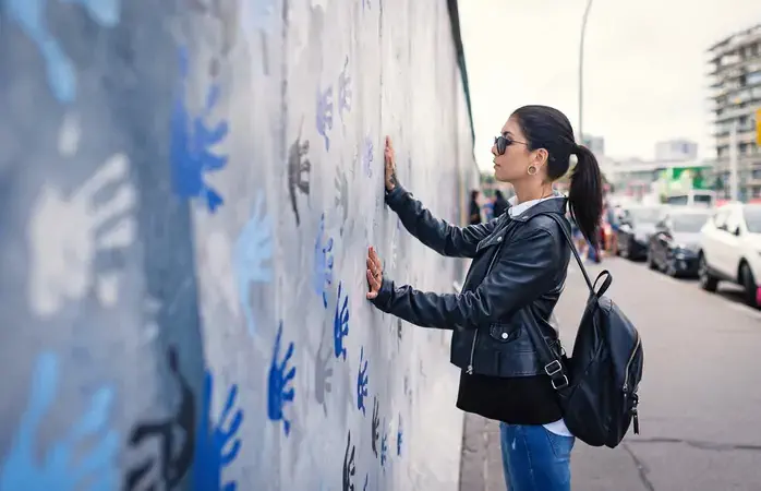Young woman in front of Berlin Wall.; Shutterstock ID 1035479575