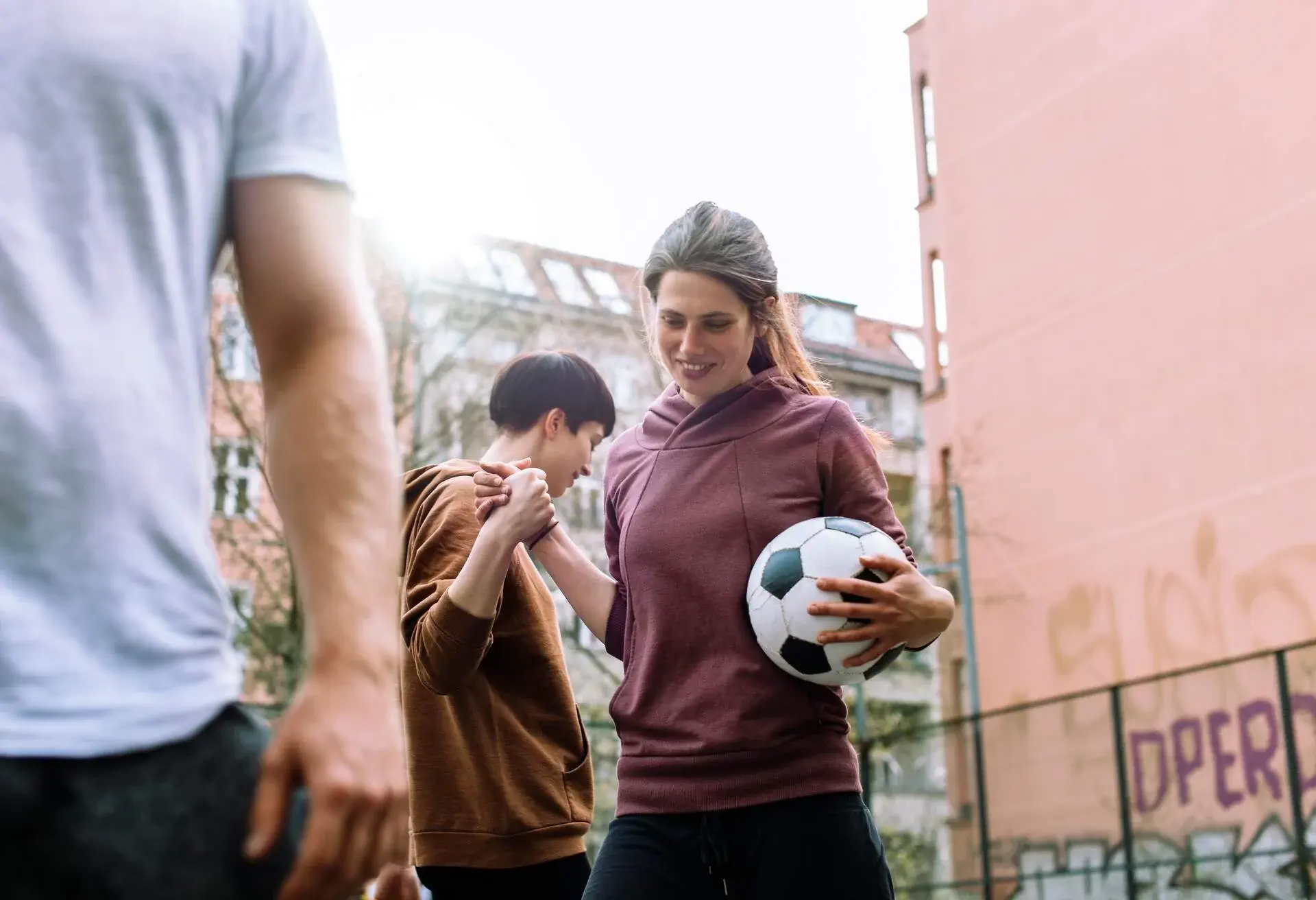 Two female team mates with soccer ball at urban sports ground