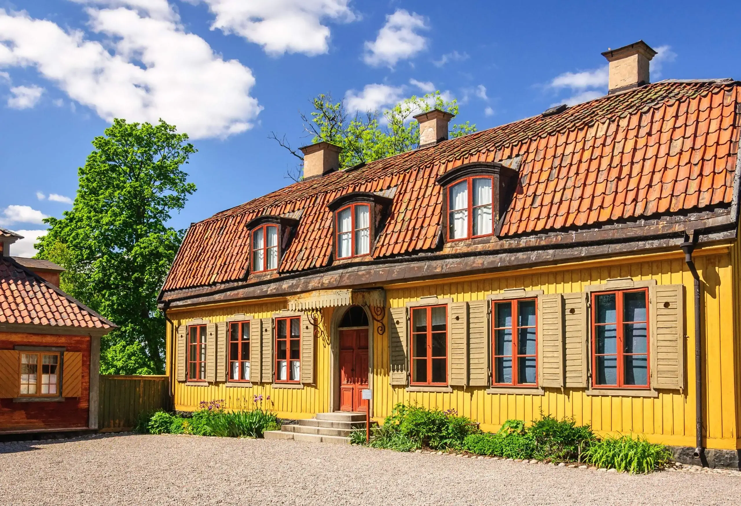 Colourful wooden cottages with tiled roofs set against a beautiful morning sky.