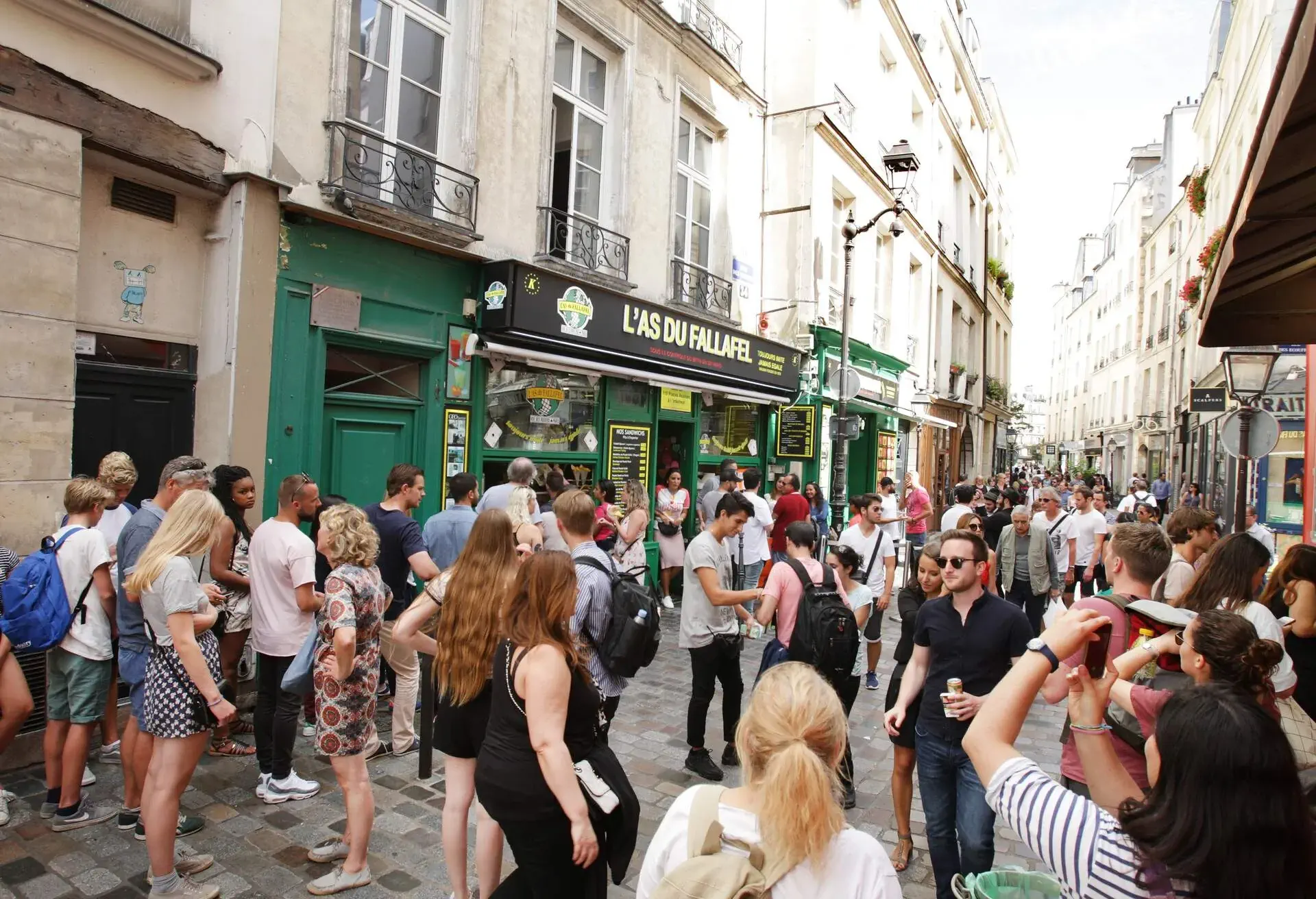 Paris,France - August 14: Tourists enjoying on the rue de Rosiers street in Le Marais district of Paris. The Le Marais district is one of Paris' main Jewish communities.