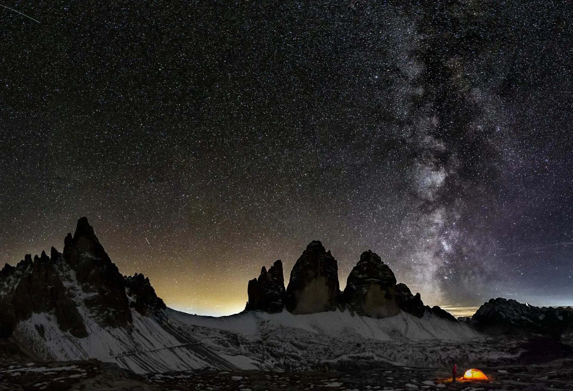 An illuminated tent in Dolomites under Milky Way at the Cime of the Dolomites (Drei Zinnen)