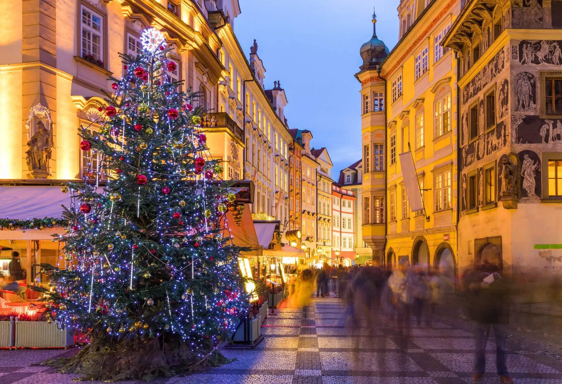 Prague Christmas market on the night in Old Town Square with blurred people on the move. Prague, Czech Republic.