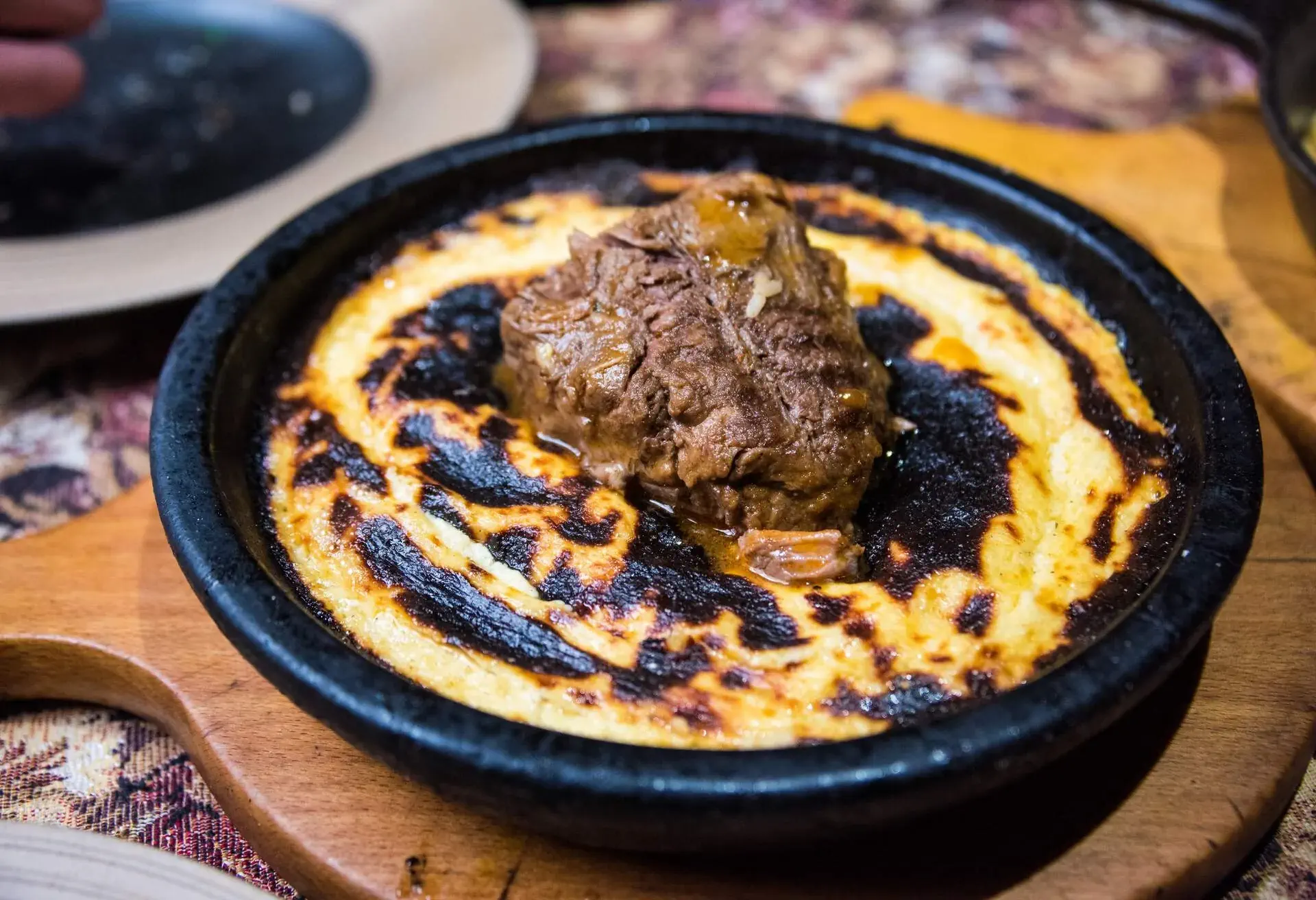 Close up of a skillet pan with Tavë kosi, Albanian casserole with veal, in a restaurant in Pristina, Kosovo