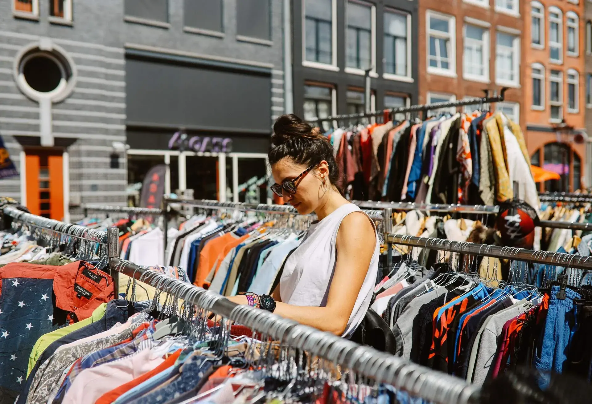 Woman looking through the Amsterdam outdoors vintage market, shopping for vintage clothing.