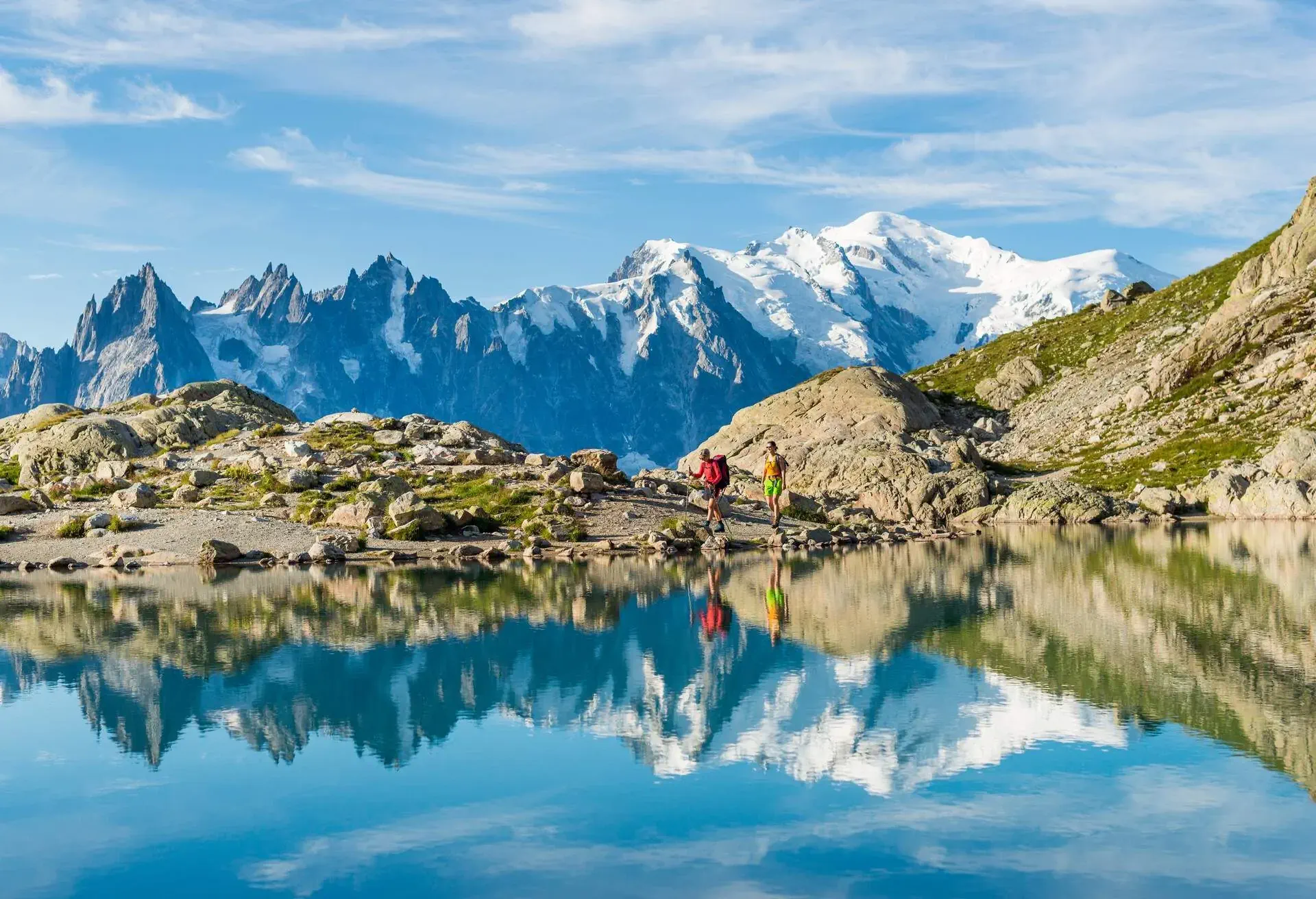 The white snowy topped domed shape summit of Mont Blanc is the highest peak on the right side