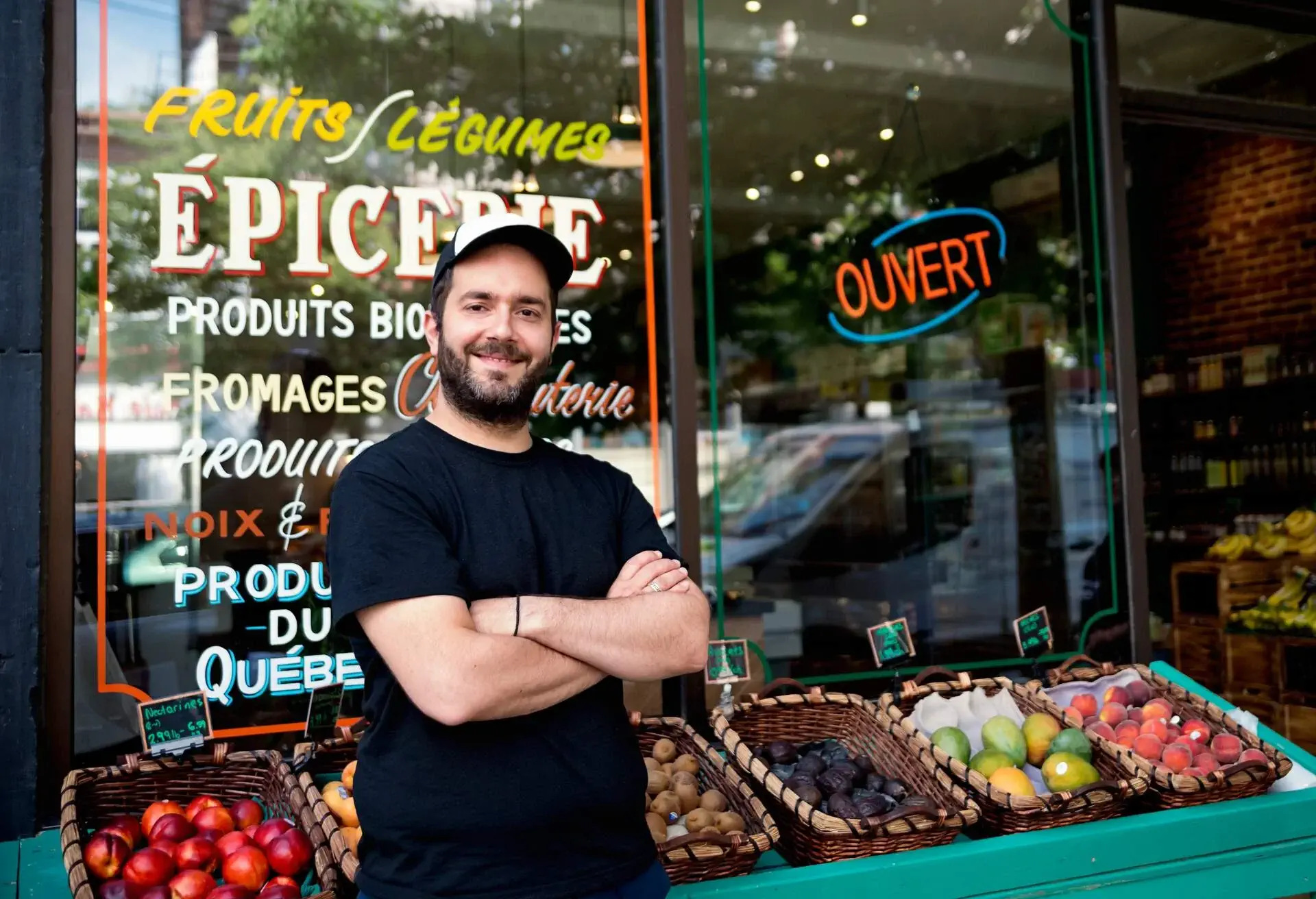 Zero waste oriented small local fruit and grocery store. Family business. Fruits and vegetables are organic and sold without wrapping. Unsold items are use to make juices, smoothies and take-out healthy food. Here the owner, posing for a portrait. Horizontal waist up outdoors shot.