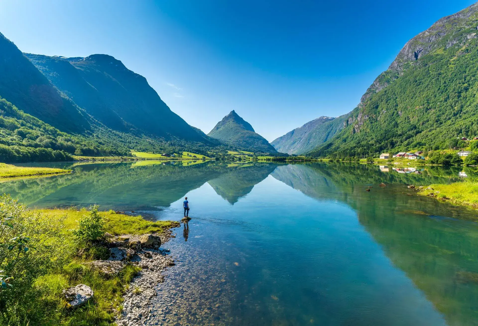 Man on banks of lake Bergheimsvatnet admiring Mount Eggenipa along the western fjords, Nordfjord, Sogn og Fjordane, Norway