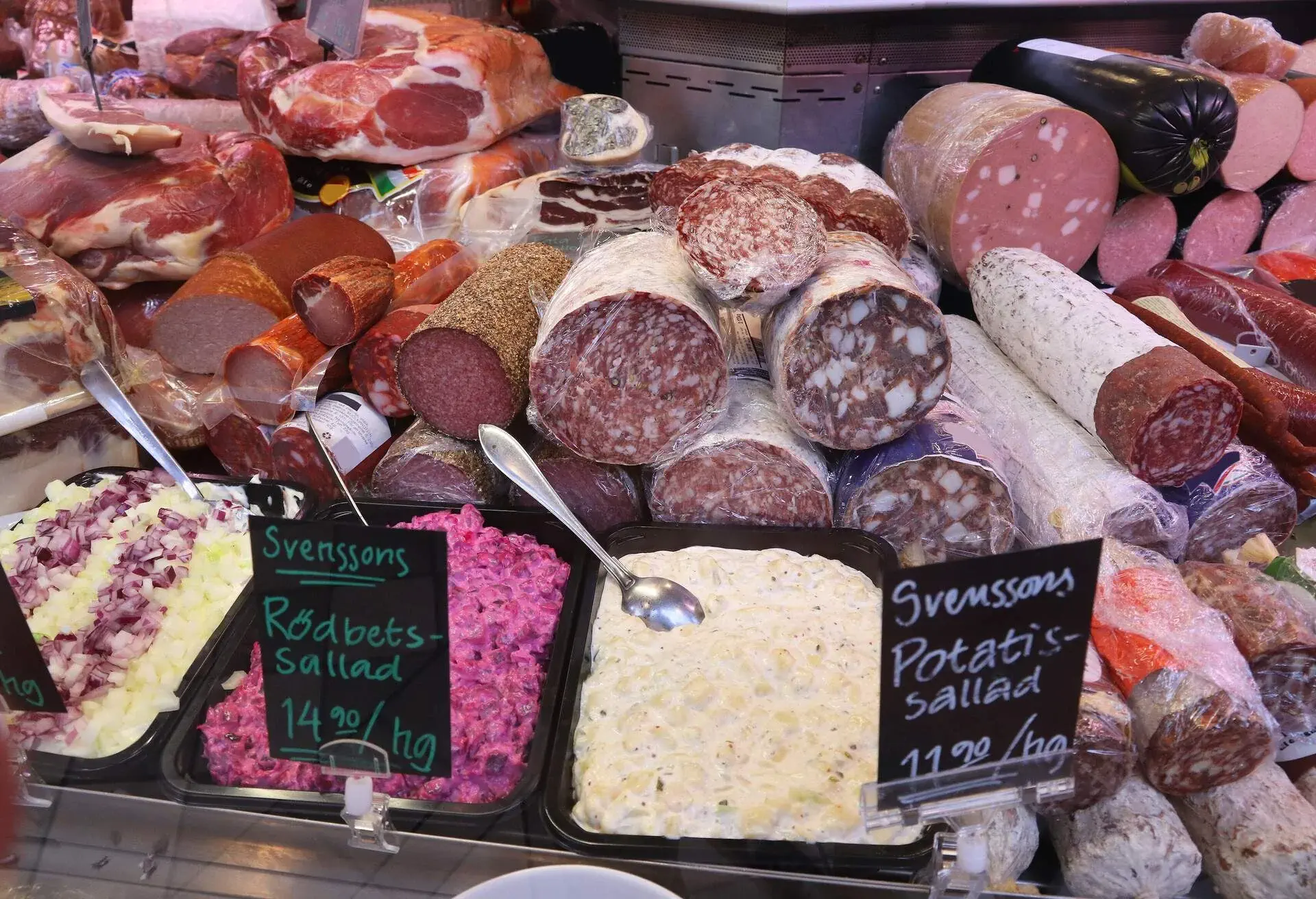 Meat store in Gothenburg Market Hall (Saluhallen), Sweden. Various smoked hams, bacons, sausages, salami and salads.