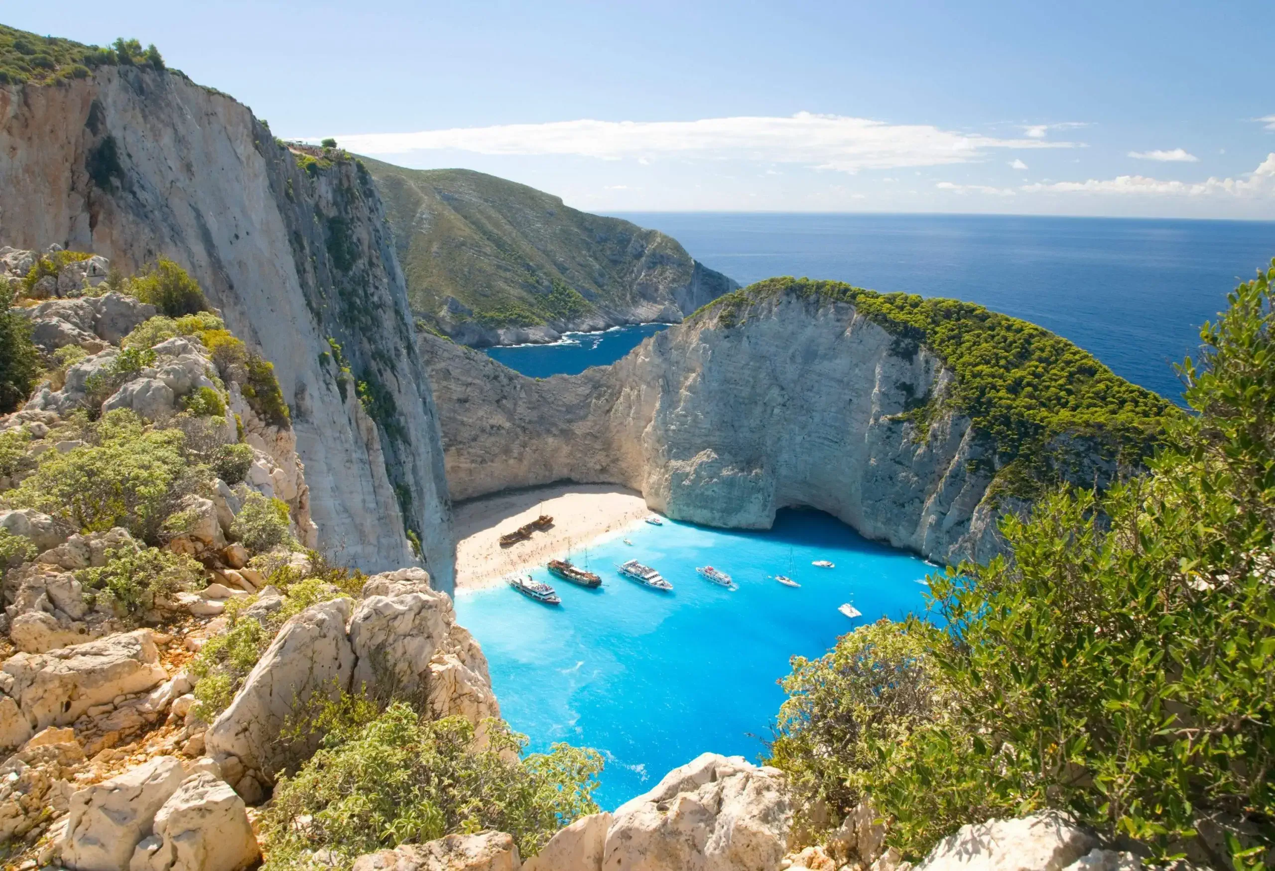 There were pleasure boats anchored off the beach, flanked by cliffs, with the turquoise ocean in the background.