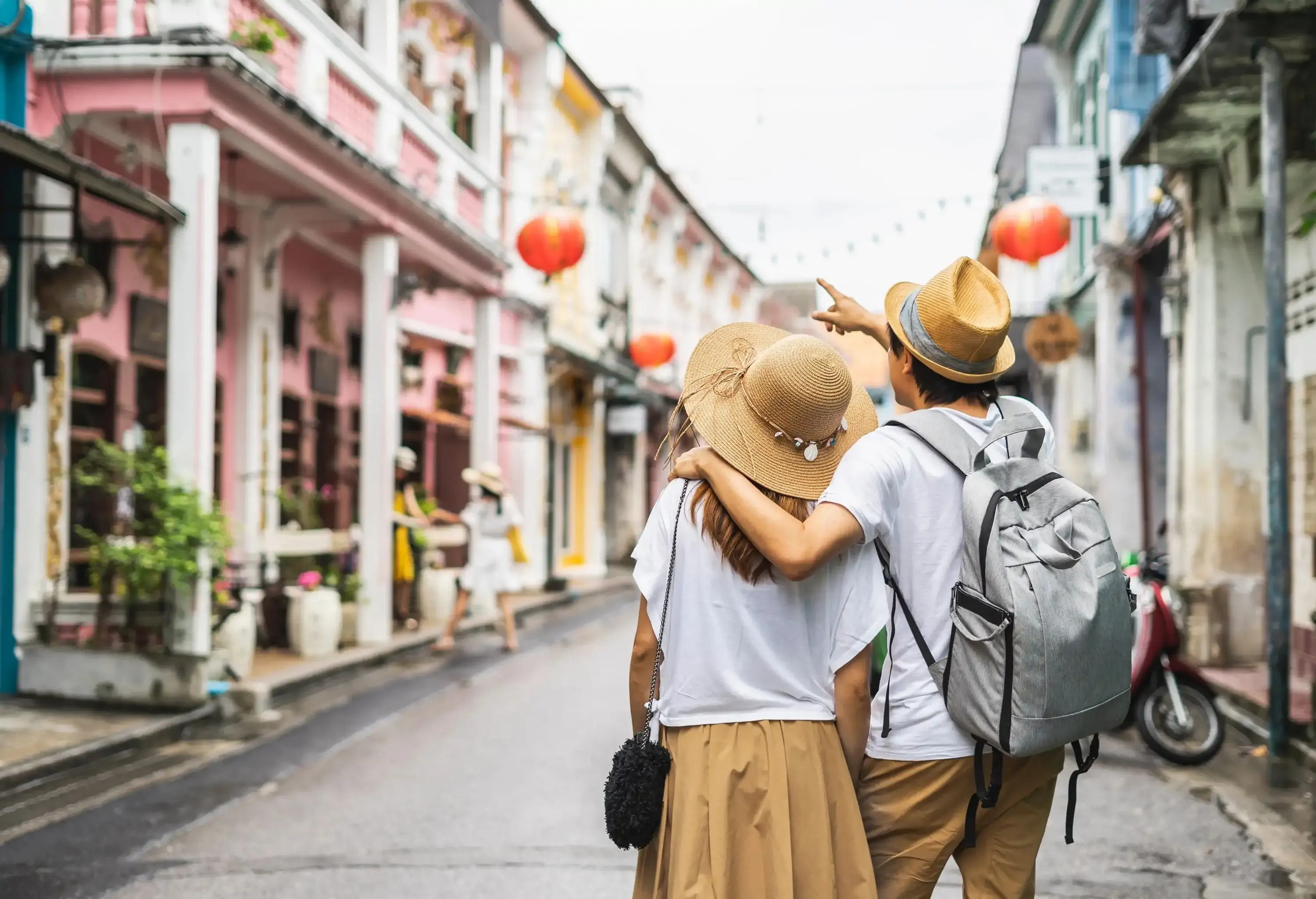 A hat-wearing pair strolling in an alley, surveying the surrounding architecture.