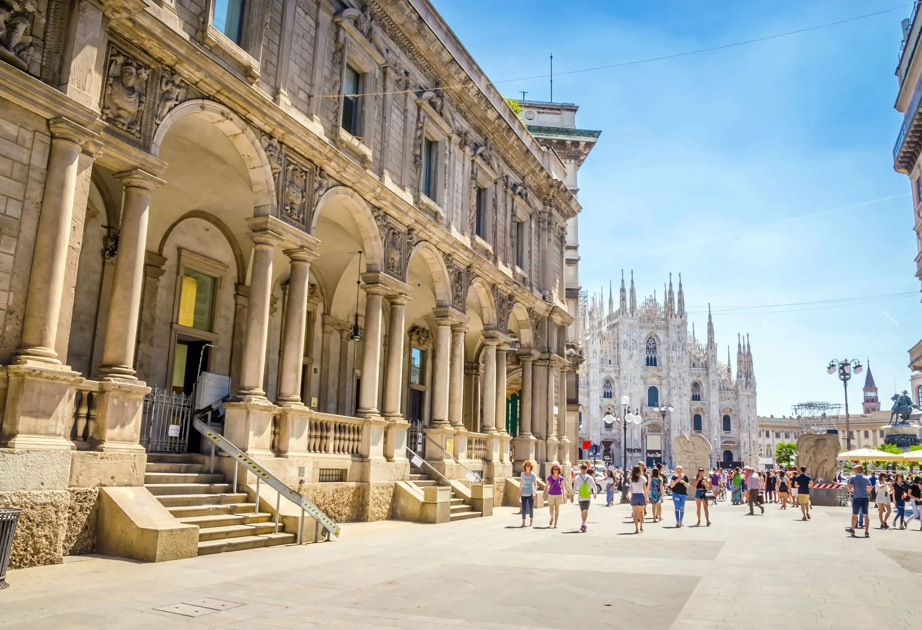 The Piazza del Duomo bustling with people strolling along the streets past the magnificent monuments.