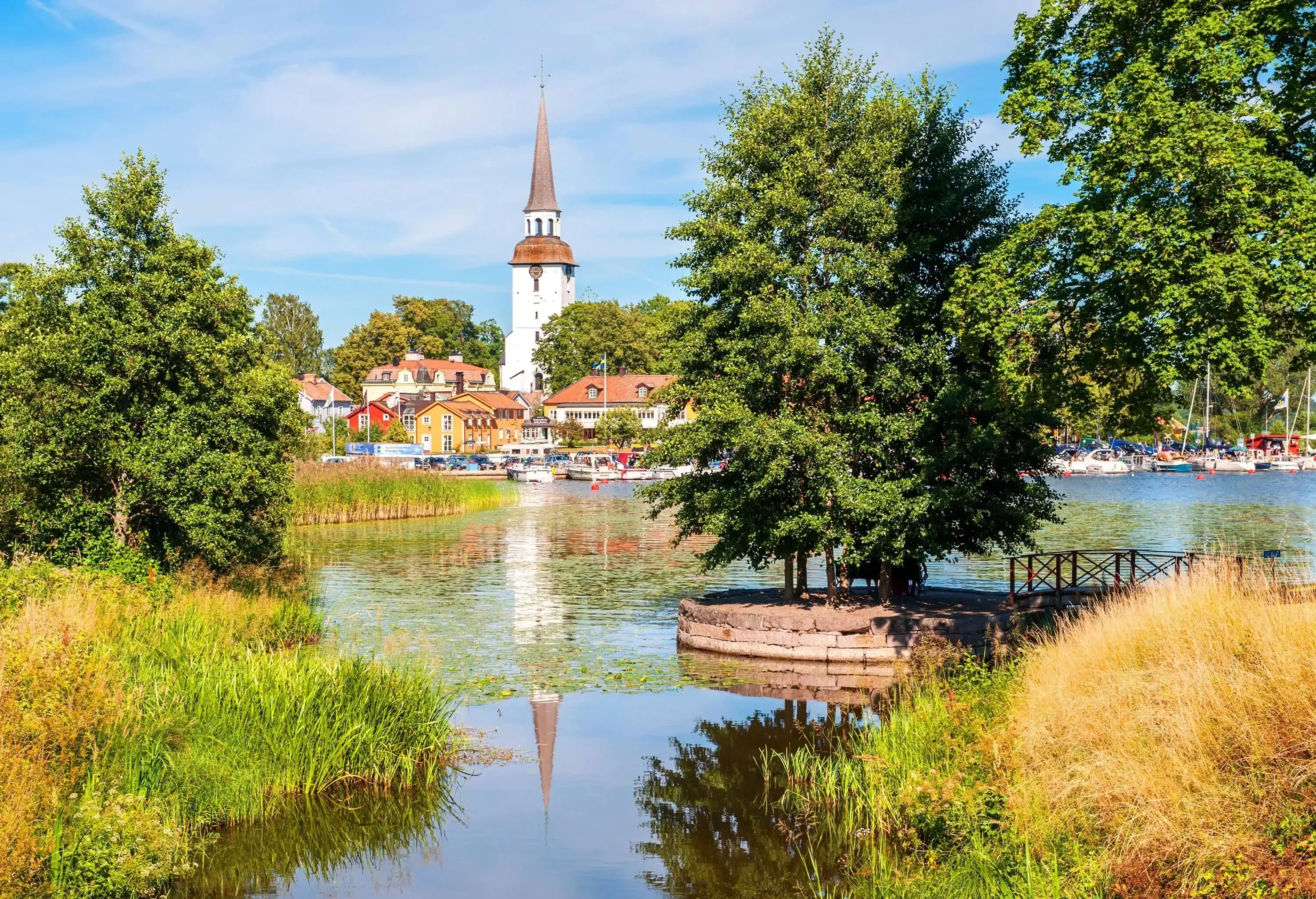 A little lakeside village with a spire rising above dwellings and buildings.
